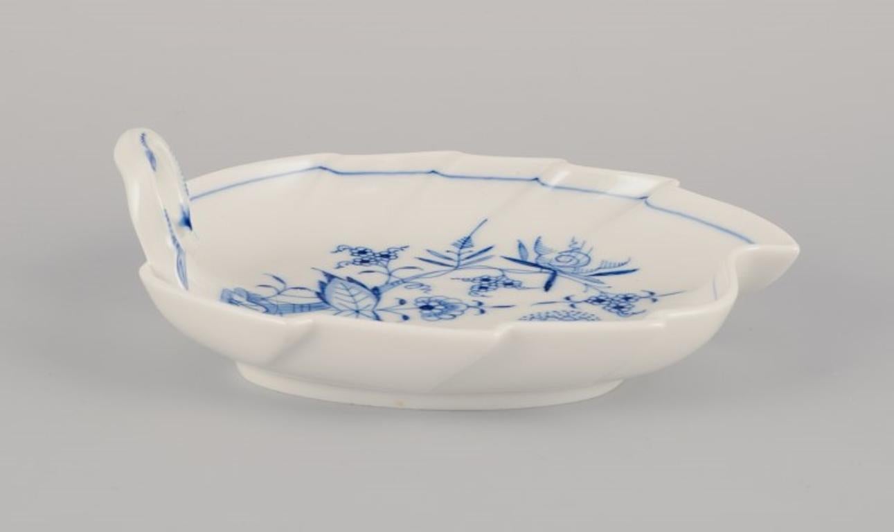 Meissen, Alemania. Patrón Cebolla Azul. Plato en forma de hoja con asa.
Pintado a mano en azul.
Mediados del siglo XX.
Marcado.
Perfecto estado.
Tercera calidad de fábrica.
Dimensiones: Largo 19,0 cm x Ancho 17,0 cm x Alto 6,0 cm.