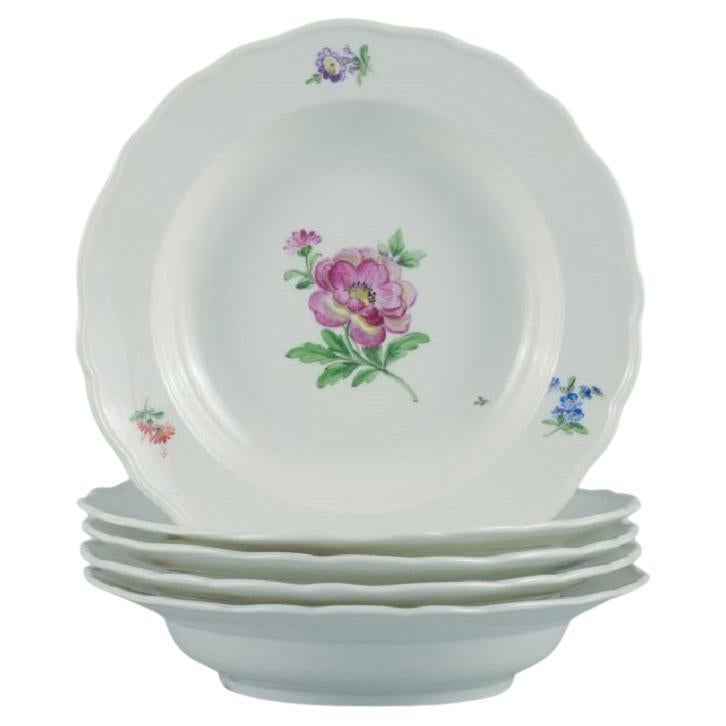 Cinq assiettes profondes en porcelaine décorées de fleurs de Meissen, Allemagne