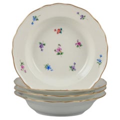 Meissen, Germany. Four deep plates in porcelain. Hand-painted with flowers