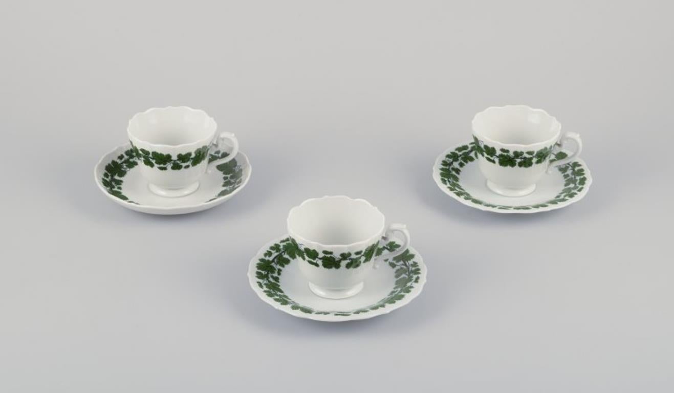 Meissen, Germany, Green Ivy Vine, three coffee cups with matching saucers. 
Hand-painted.
1920s/30s.
Marked.
Two cups in first factory quality. One cup in third factory quality.
In perfect condition.
Cup: D 8.0 cm without handle x H 6.2 cm.
Saucer: