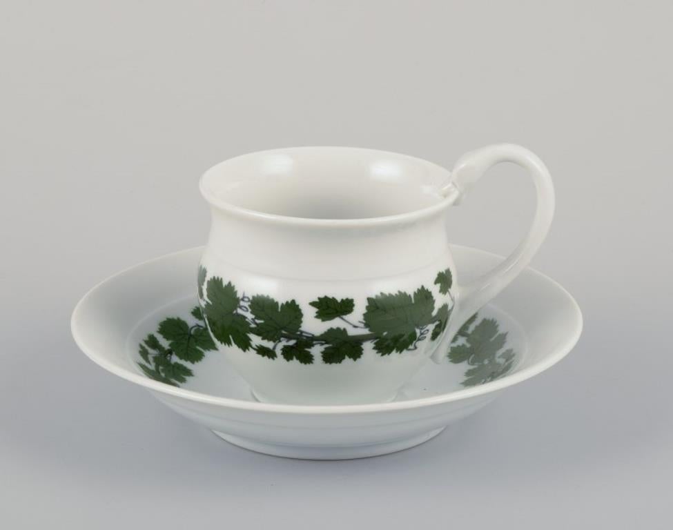 Meissen, Deutschland, Green Ivy Vine, zwei Kaffeebecher mit hohen Henkeln und Untertassen. Eine Tasse hat einen Schwanenkopf als Henkel. Handbemalt.
1920er/30er Jahre.
Markiert.
Erste Fabrikqualität.
In gutem Zustand, obwohl eine Tasse einen Chip im