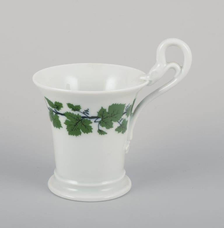 Meissen, Germania, Greene & Greene, due tazze da caffè con piattini.
Una di queste con manico alto e testa di cigno. Dipinto a mano.
Anni '20-'30.
Contrassegnato. 
Prima qualità di fabbrica per le tazze, un piattino in terza qualità.
Tazze: H. 6,3