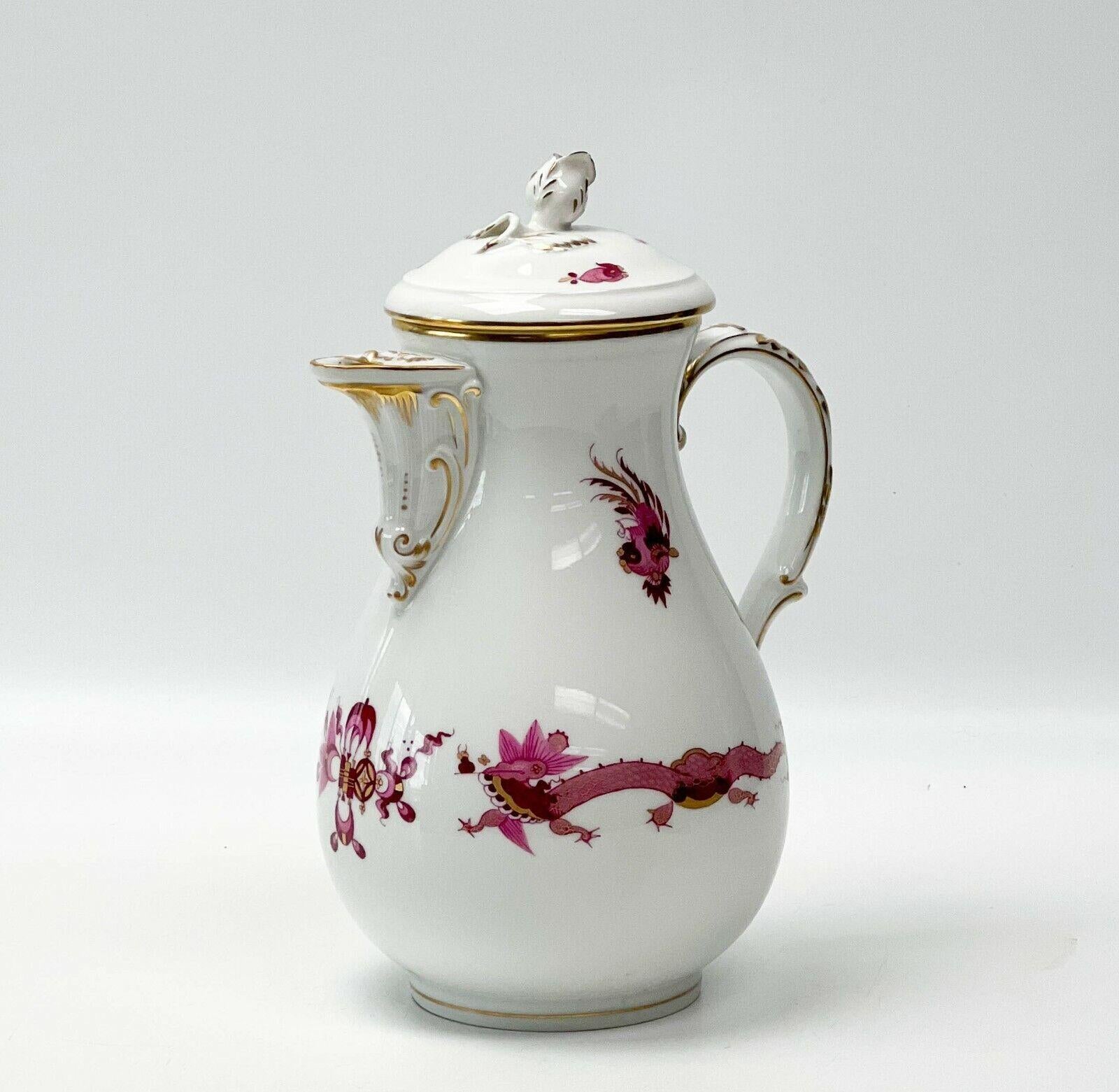 Meissen Germany Kakiemon Dragon Hand Painted Porcelain Coffee or Chocolate Pot. A white ground with hand painted Kakiemon style pink bodies of dragons to either side, florals and ribbons. Gilt accents, gilt to the handle, spout, and rim. A rose
