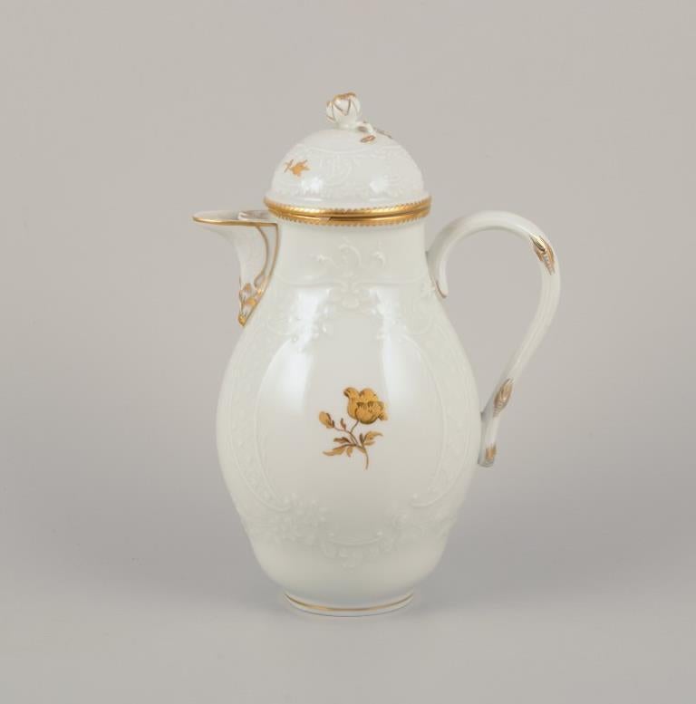 Meissen, Germany. 
Porcelain coffee set comprising a coffee pot, creamer, and sugar bowl. 
Hand-decorated in gold with flowers in a classic style. 
Early 1900s.
Marked.
Perfect condition. 
Third factory quality.
Coffee pot: H 19.5 cm x W 14.0 cm