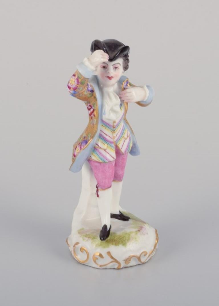 Meissen, Germany. Porcelain figurine of a young man in elegant attire. 
Hand-painted in polychrome colors.
19th century.
Marked.
In perfect condition.
First factory quality.
Dimensions: Height 11.0 cm x Diameter 5.0 cm.