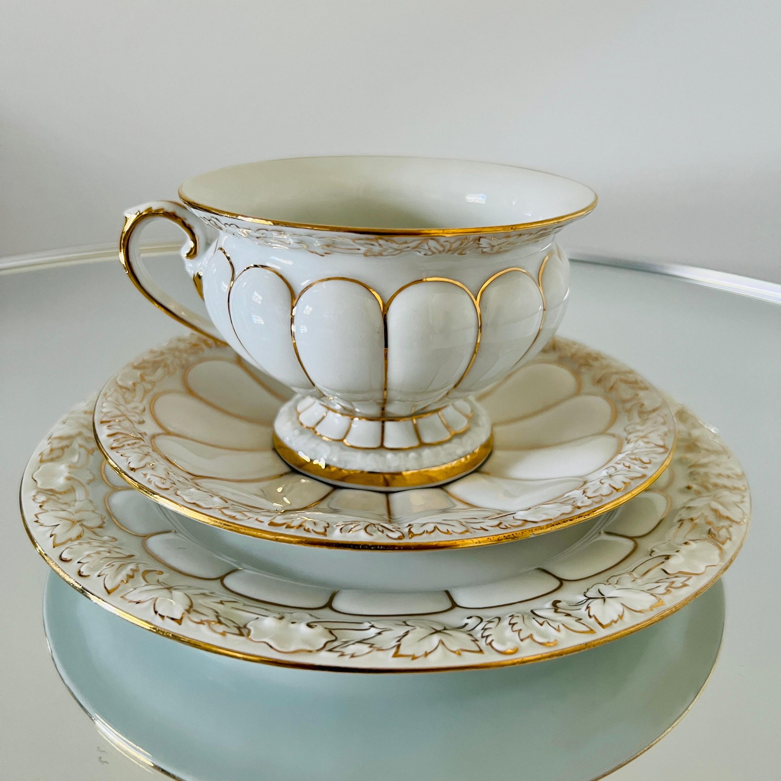 Meissen porcelain set from the opulent Golden Baroque series handmade in Germany.  The set includes 40 pieces - 13 coffee cups / 16 saucers / 11 dessert plates.  The cups, saucers, and dessert plates have a white glaze finish with ornamental relief