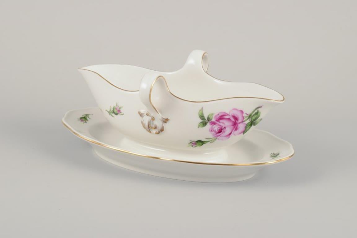 Meissen, Allemagne. Saucière sur un Stand avec un motif de rose rose. 
Bordure en or.
Vers les années 1920/30.
En parfait état. Comme neuf.
Marqué.
Cinquième qualité d'usine.
Dimensions : L 24,0 cm. x L 15,0 cm. x H 10,0 cm : L 24.0 cm. x L 15.0 cm.