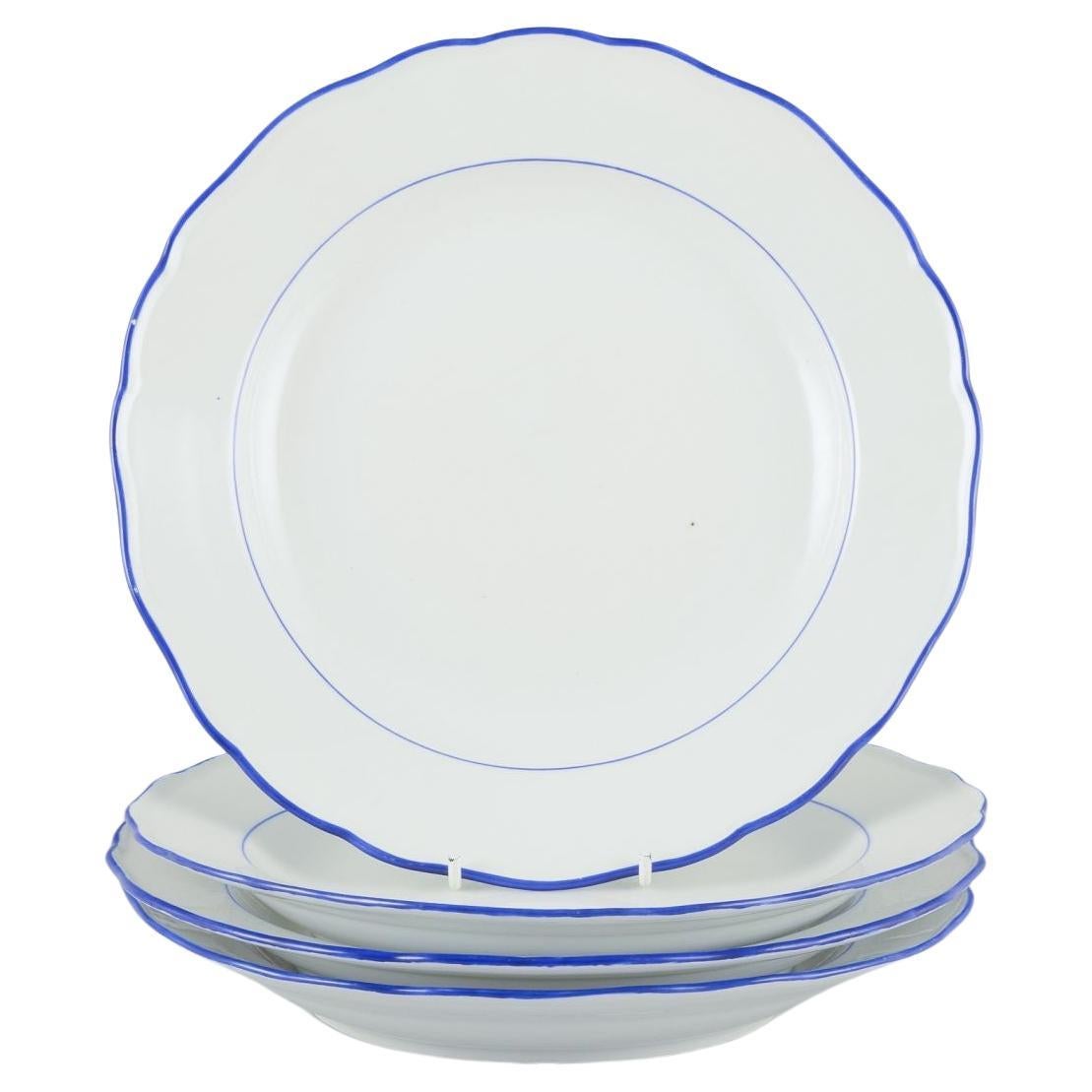 Meissen, Germany. Set of four dinner plates. White porcelain with blue rim.