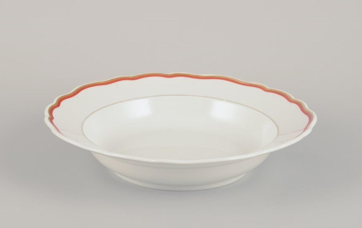 Meissen, Alemania. Juego de porcelana de tres piezas compuesto por un cuenco grande, un plato hondo y un plato. Decorado con rojo coral y ribetes dorados. Art Déco.
Ca. 1930s.
Marcado.
Tercera calidad de fábrica.
En excelente estado, sin