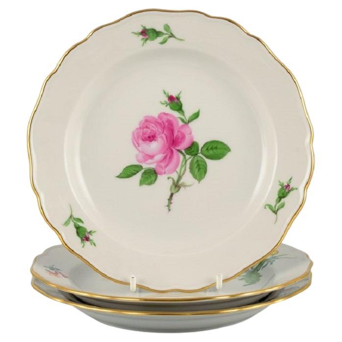 Meissen, Allemagne, trois assiettes peintes à la main avec des fleurs et des décorations en or.