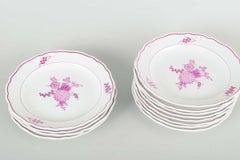 Meissen, Germany. Twelve deep porcelain plates with floral motifs in purple/pink