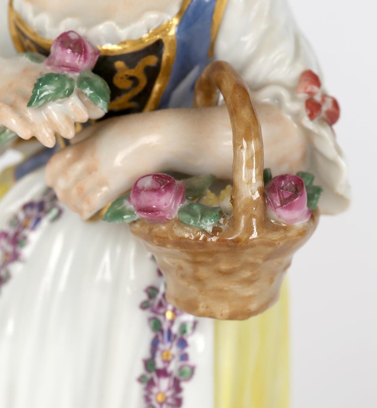 A very fine German porcelain figure of a girl with basket and flowers after a model by JJ Kaendler made by Meissen and believed to date from the early 20th century. This finely made figure stands on a scroll work base applied with flowers and gilded