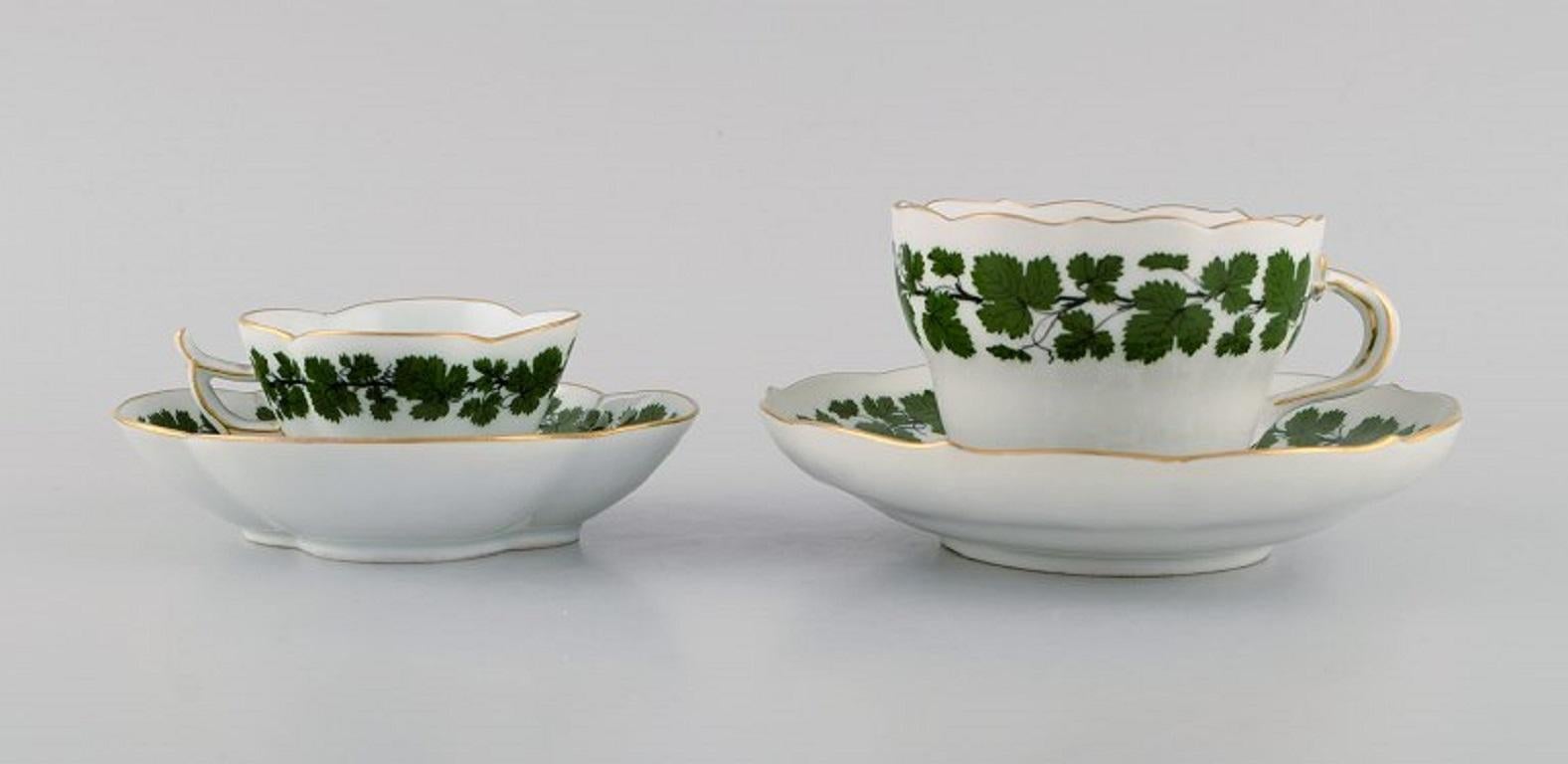 Meissen Green Ivy Vine Leaf Mokka- und Teetasse aus handbemaltem Porzellan mit Goldrand. 
1920er/30er Jahre.
Die Teetasse misst: 9 x 6,5 cm.
Durchmesser der Untertasse: 14,8 cm.
Die Mokkatasse misst: 7 x 4,5 cm.
Durchmesser der Untertasse: 12,3