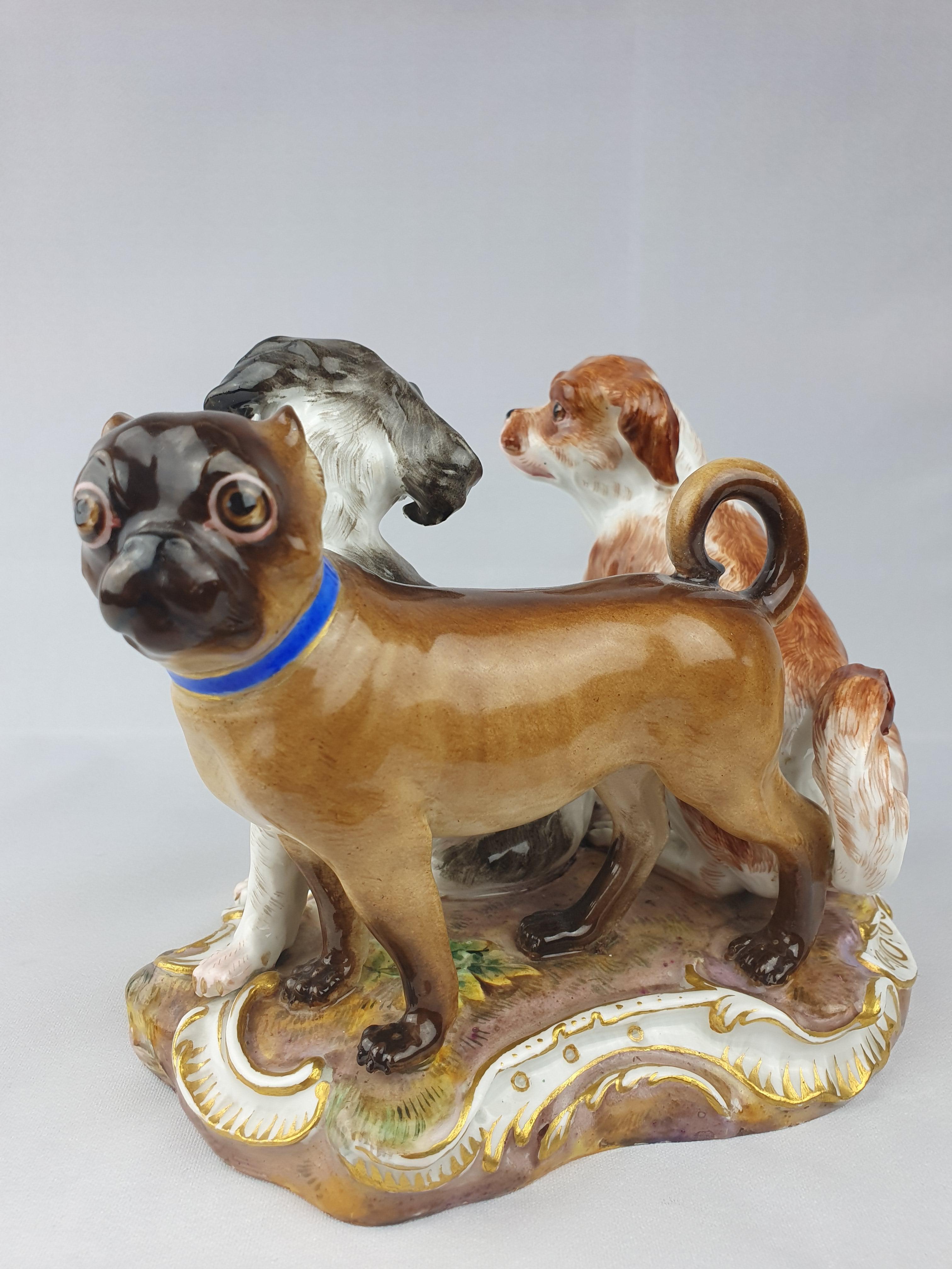 Meissen Group of Three Dogs two Bolognese Spaniels and a Pug dog sat on a grassy mound base.- Modelled by Kaendler.

circa 1850.
Height 14cm / 5.5inch.