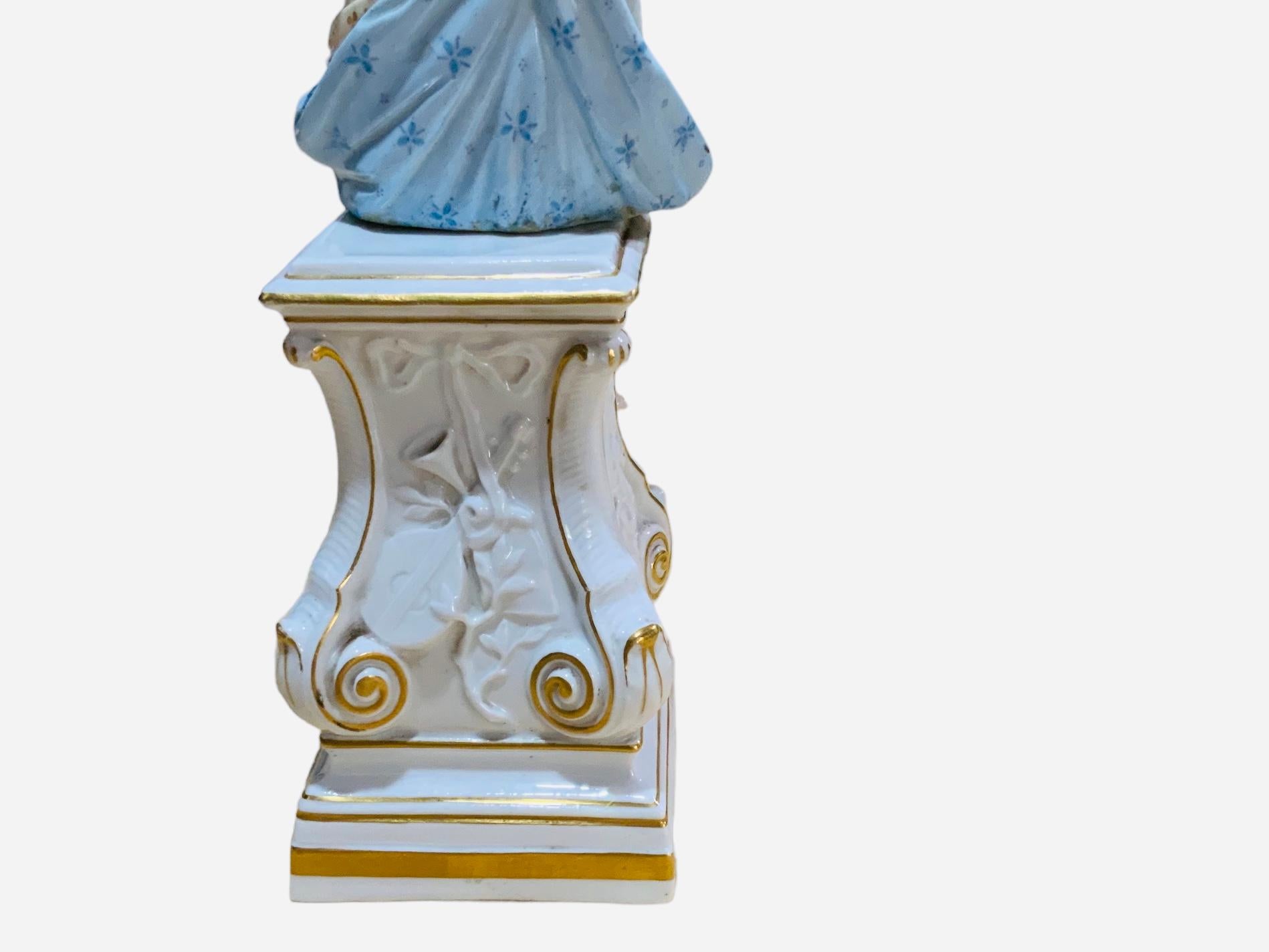 Figurine de la Muse de la mythologie grecque en porcelaine de Meissen jouant du luth. Elle peut être Erato, l'a.muse de la poésie lyrique, en particulier de la poésie érotique et de l'imitation mimique. Elle représente une femme vêtue d'une robe