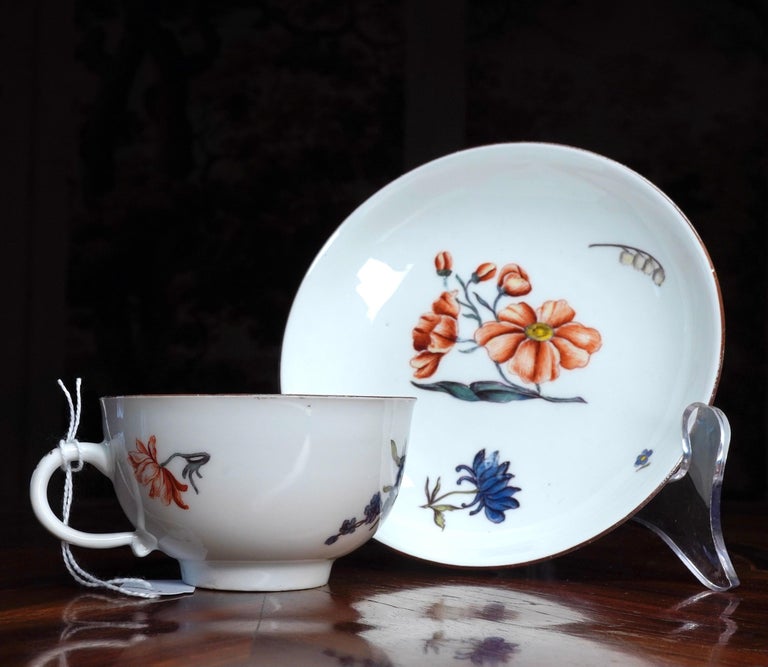 Meissen cup and saucer, well painted with Holzschnittblumen flowers, within brown line rims,
circa 1750.