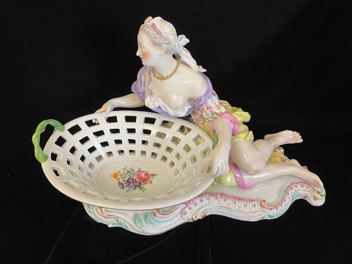 Figurative almond bowl with nice lady laying next to it. The version with a basket instead of a bowl is pretty rare. Decent and very elegant painting. 

About 12 inches wide. Perfect condition.