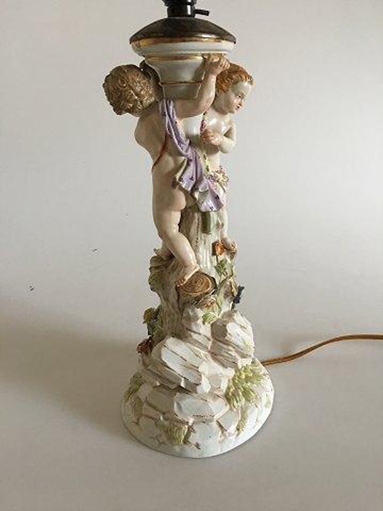 Meissen lamp with figurines. 

Measures 29cm high to the start of the mounting. Has a few chips here and there on the flowers.
 