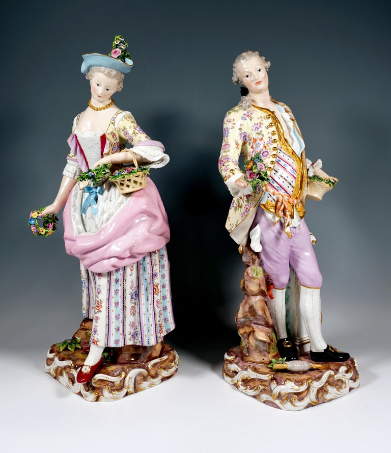Gardener couple consisting of two individual figures.
The female gardener wears rural rococo clothing: a dress with elaborate floral decoration and a pinned up apron, corset and borders made from fine dipped lace, a brimmed hat with floral