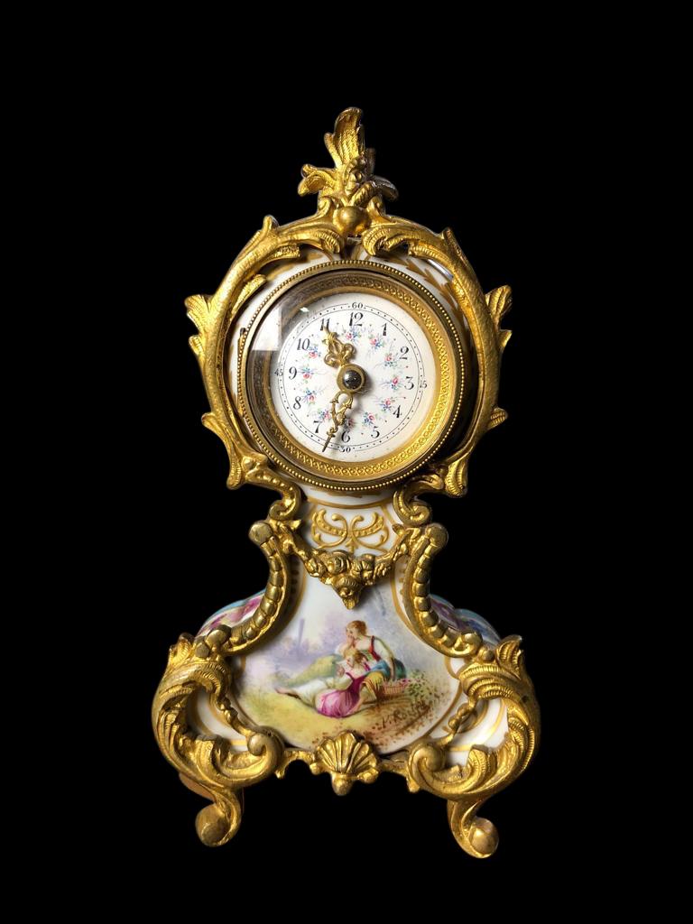A spectacular Meissen mantel (fireplace) table clock, 19th century. The clock is offered in great original condition, with a stunning gold gilded frame, and hand painted scenes of a couple on the front followed with floral decoration on back and