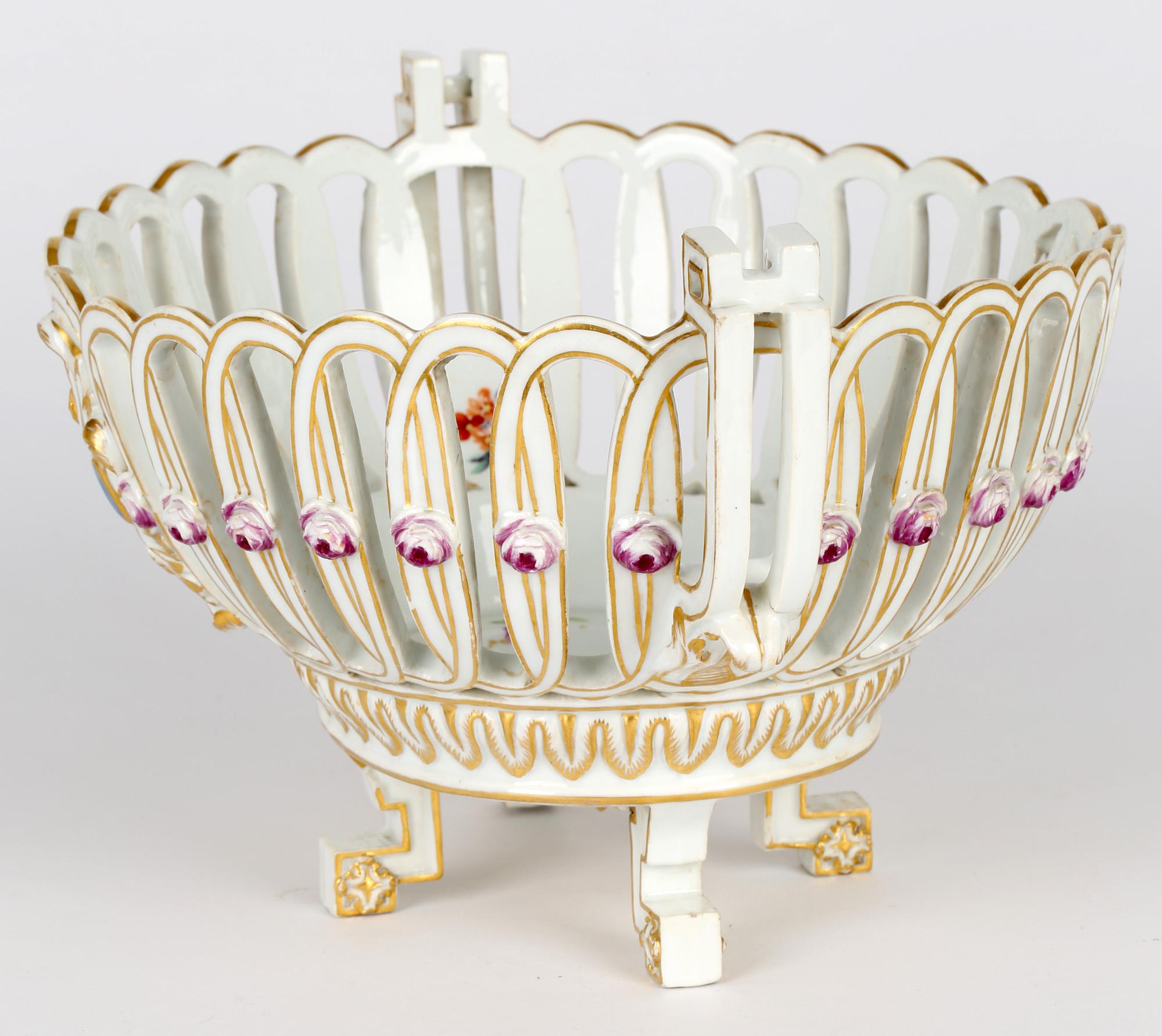A fine antique German porcelain twin handled fruit basket by prolific makers Meissen and dating from the Marcolini period 1774 to 1814. The fruit basket stands raised on four Greek key key shaped legs with decorative terminals with a neoclassical