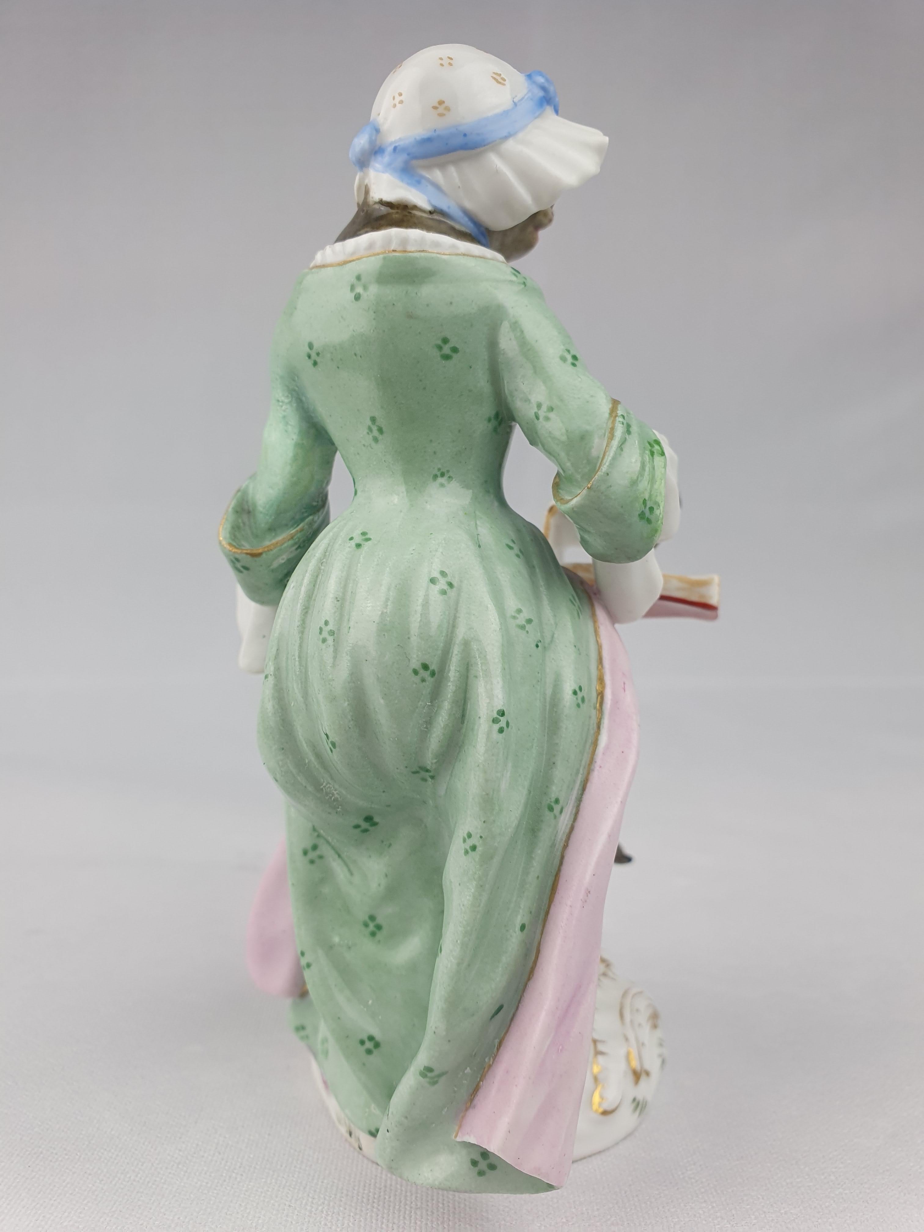 Meissen Monkey Singer no10 in the Monkey band collection. Sitting with a song sheet on her knee.

From a series of Monkey band players originally modelled by J.J Kaendler.
Height is 13cm.
circa 1880.