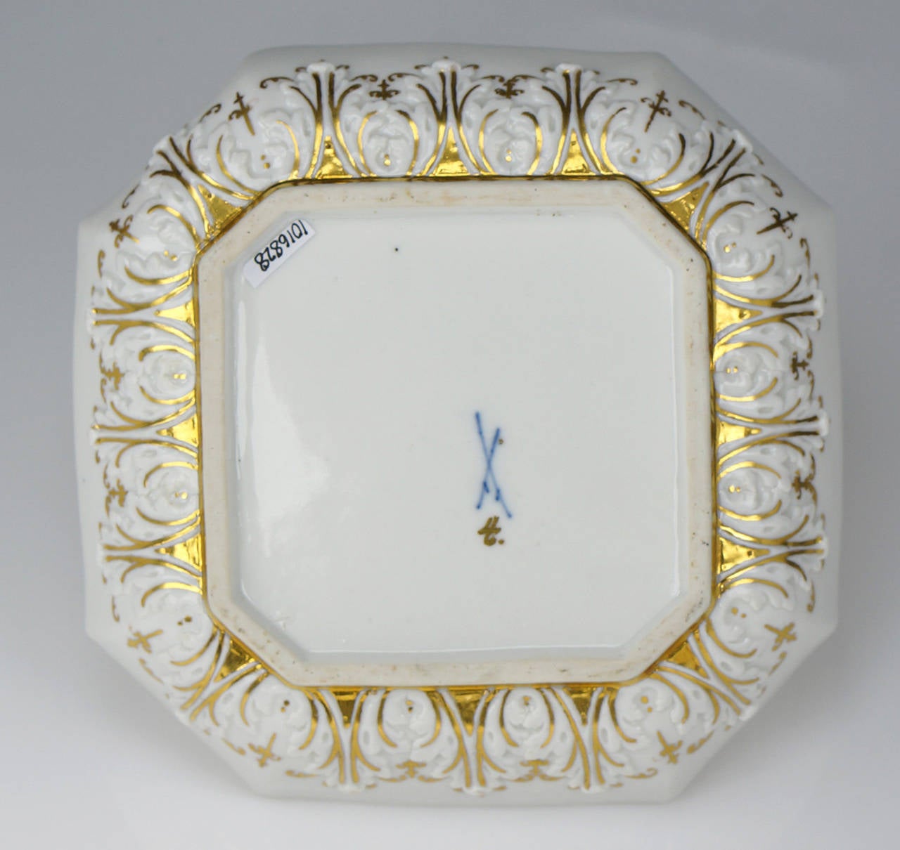 Meissen octagonal dish, painted to the centre with a chinoiserie in the manner of J.G.Ho¨roldt with a noisy scene of bell-ringers, a child to one side beating a gong, with various insects & birds flying overhead, within a double red line circle, a