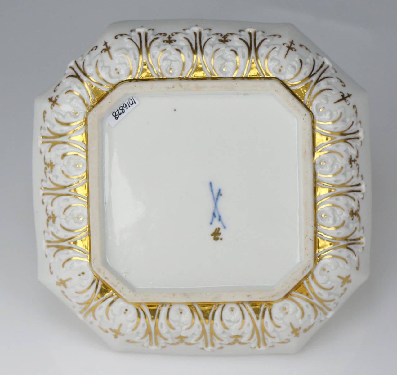 Meissen octagonal dish, painted to the centre with a chinoiserie in the manner of J.G.Ho¨roldt with a noisy scene of bell-ringers, a child to one side beating a gong, with various insects & birds flying overhead, within a double red line circle, a