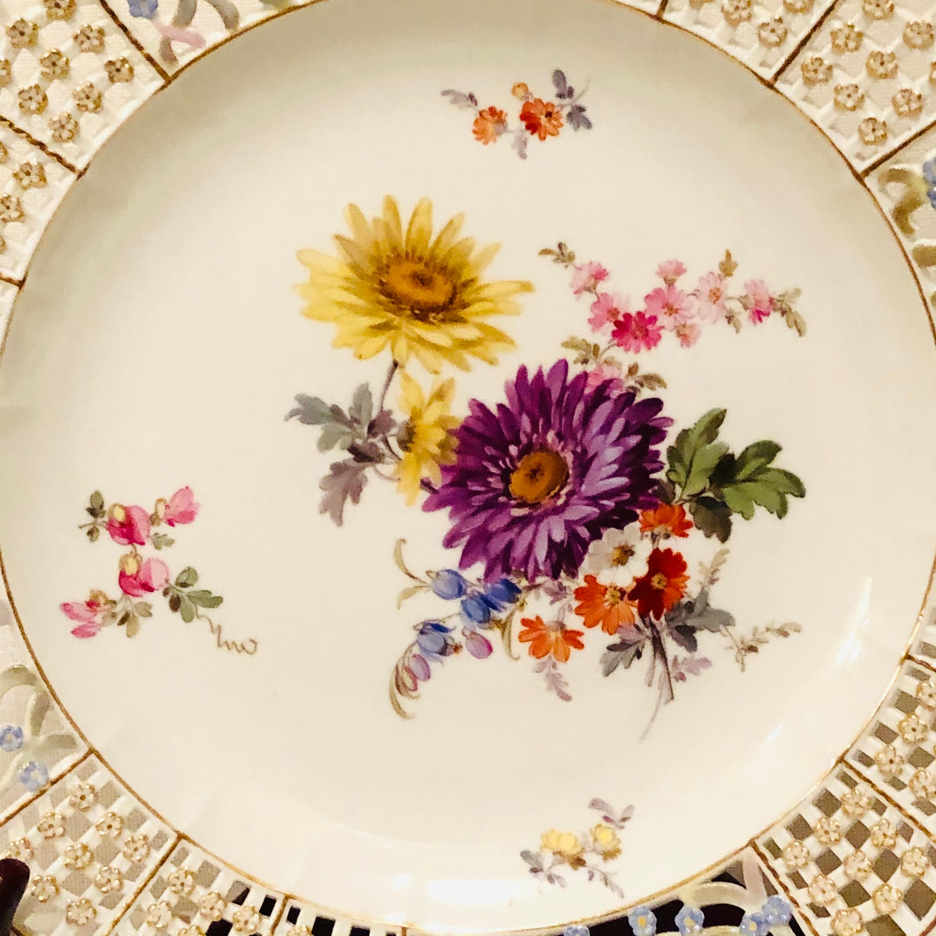 This is an exquisite Meissen cabinet plate painted with a large beautiful flower bouquet. The Meissen plate has a very intricate reticulated or open work border profusely decorated with raised gold and blue forget me nots. This Meissen plate is from