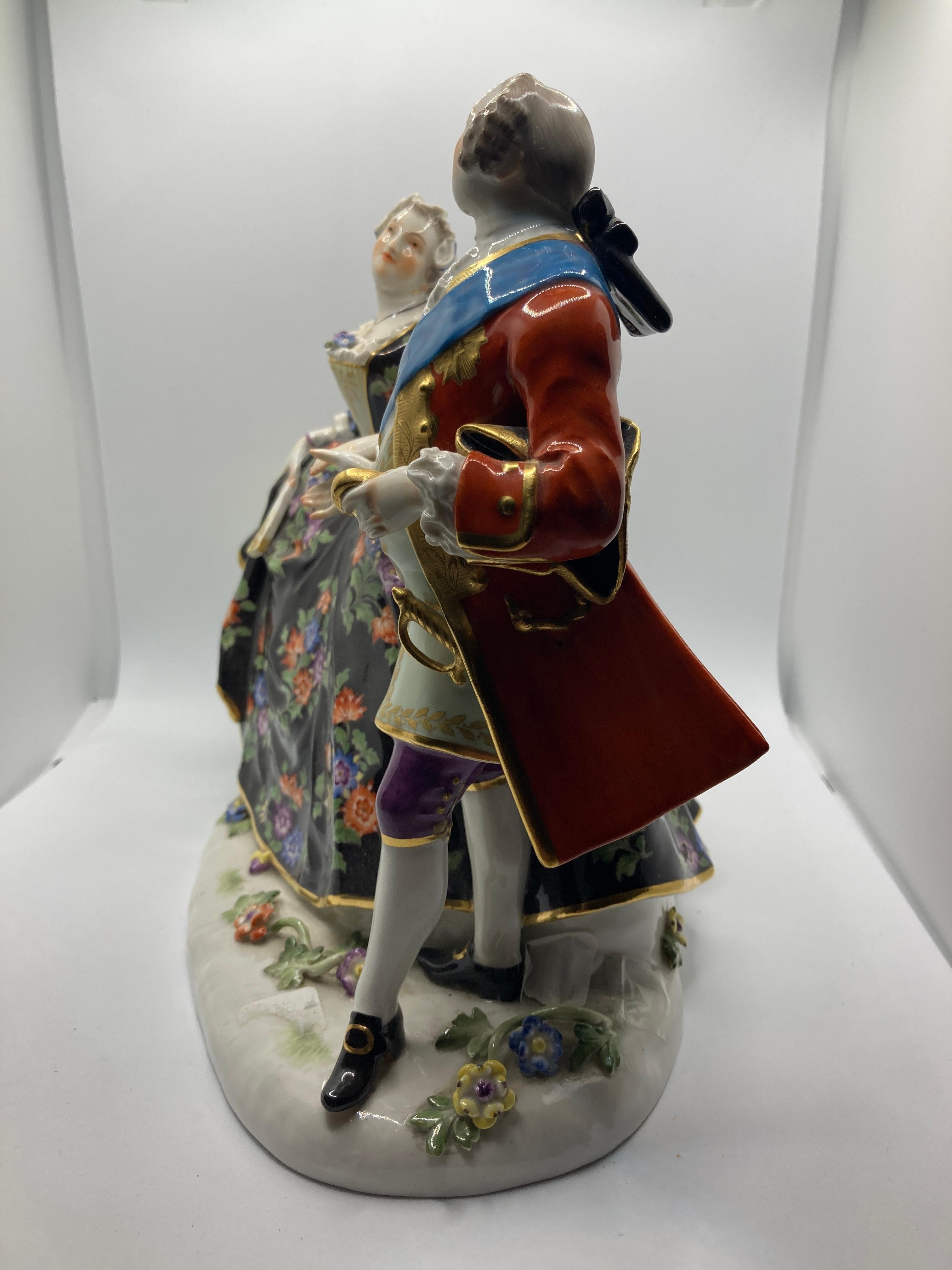 Meissen Figures at a Ball , Model No 550, 20th Century version 

Cavalier with the Polish Order of the White Eagle in his hand (here as a golden box), the lady with a cross pendant (originally conceived with a medal pendant). Colourfully decorated.