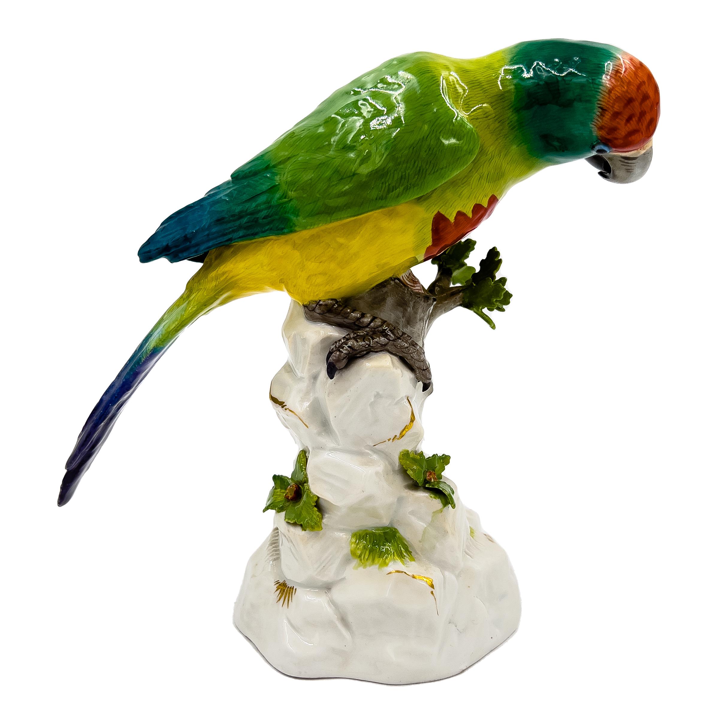 Meissener Papagei auf einem Baum aus dem 19. Jahrhundert, fachmännisch gearbeitet mit realistischen Details. Dieses mehrfarbige Meisterwerk zeigt den Papagei auf einem Baum, der mit leuchtenden Blumen und Blättern geschmückt ist. Am Sockel prangt