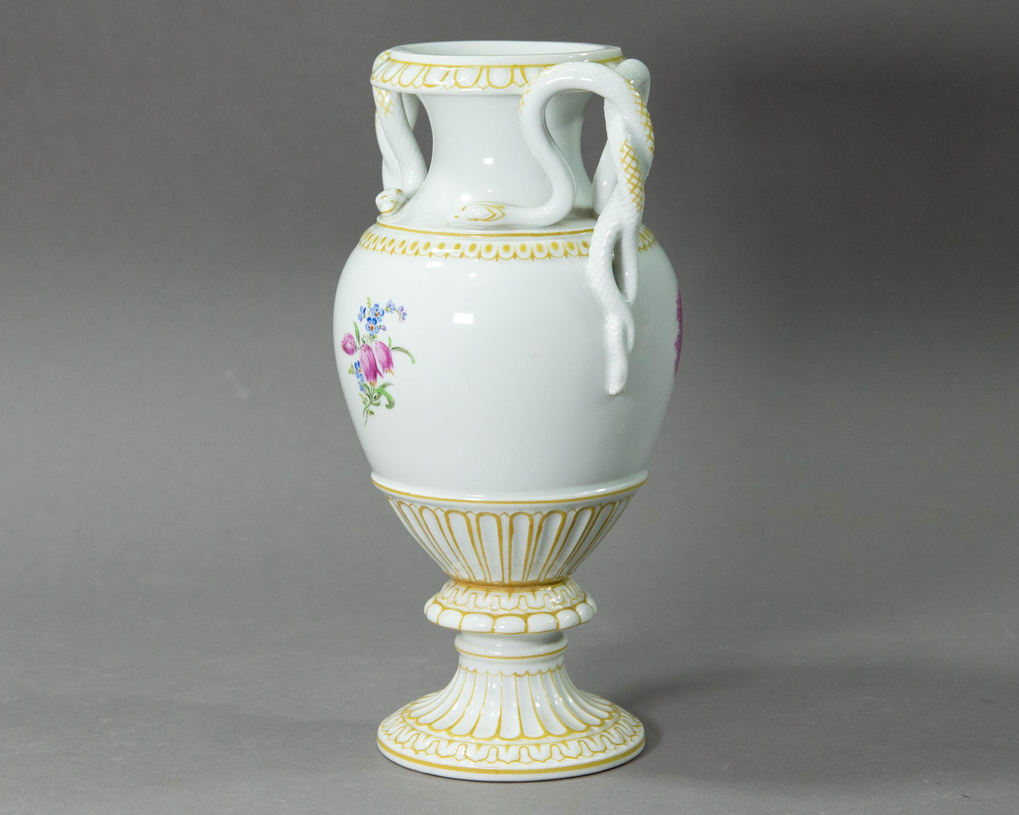 A stunning snake handled porcelain vase made by Meissen in Germany.

The vase has a beautiful classical shape and is decorated with lush hand painted floral bouquets and lines in ochre. The vase carries Meissen's mark with a dot between the blades