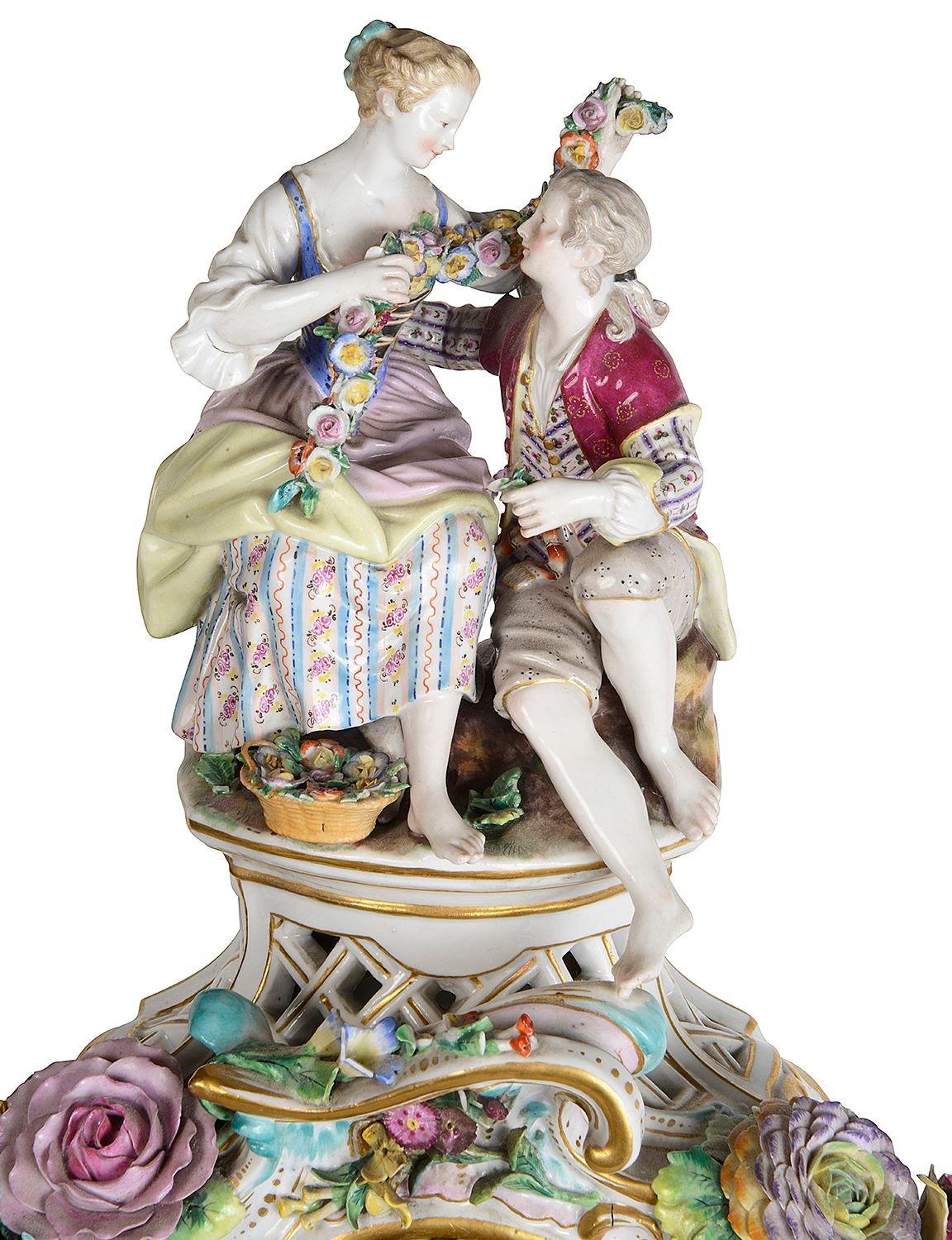 An impressive 19th Century Meissen porcelain mantle clock on stand. Depicting seated lovers with a garland of flowers. The white enamel clock face with roman numerals, an eight day duration movement that strikes on the hour and half hour. Wonderful