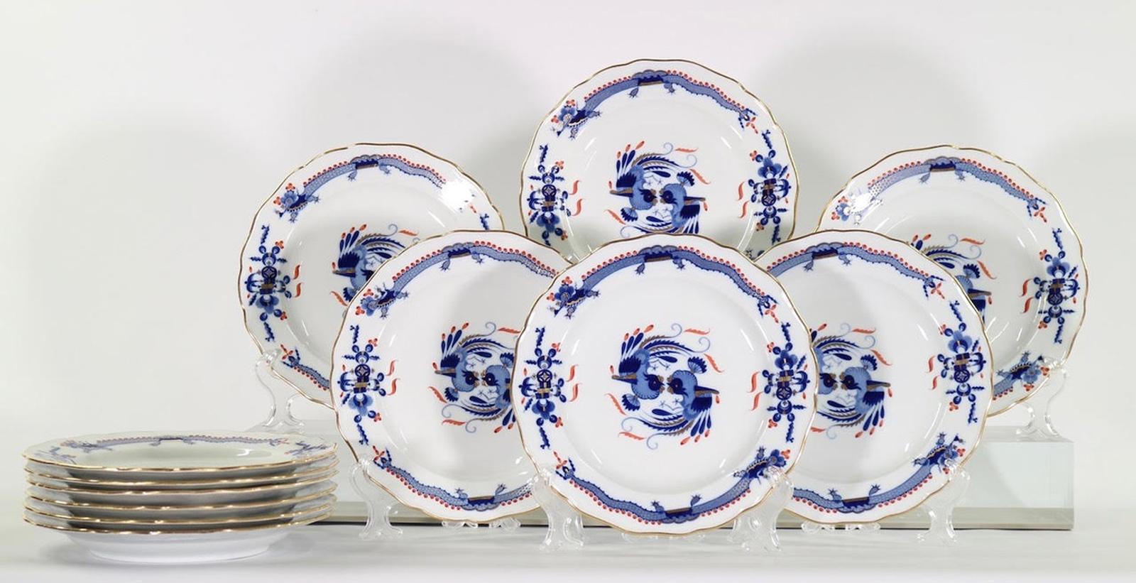 Set of twelve scalloped porcelain dinner plates in a Blue Dragon pattern, made by Meissen in Germany. The plates have decorative gold accents and date from the early 20th century. In mint condition with no scratches.