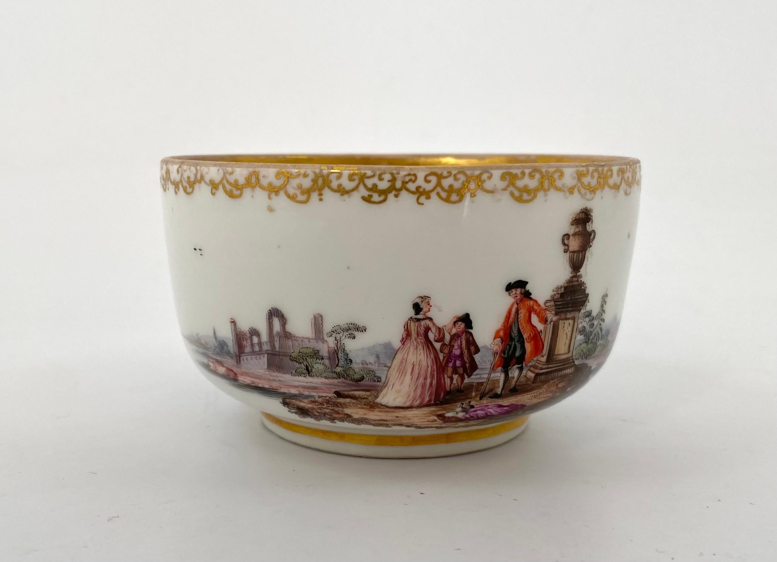 Meissen porcelain bowl, c. 1735. Hand painted to one side, with a scene of figures in Turkish costume, standing before boats in a harbour. The reverse with figures in 18th Century costume, before a large Classical urn, on a river bank, before a
