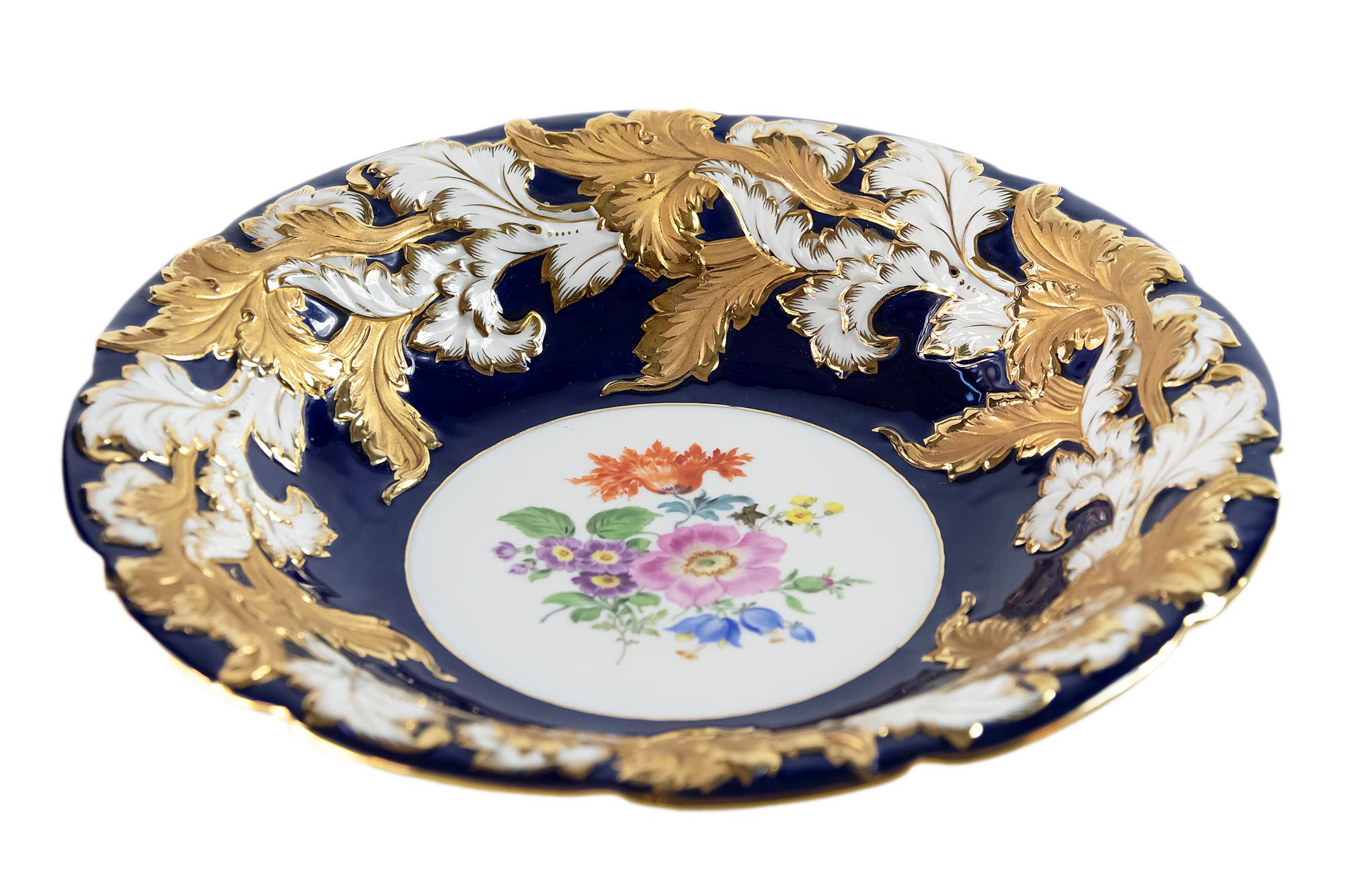 Meissen Porcelain deep cabinet plate/bowl is cobalt blue color with rich gold decor.
It is hand painted with floral motive in the center.