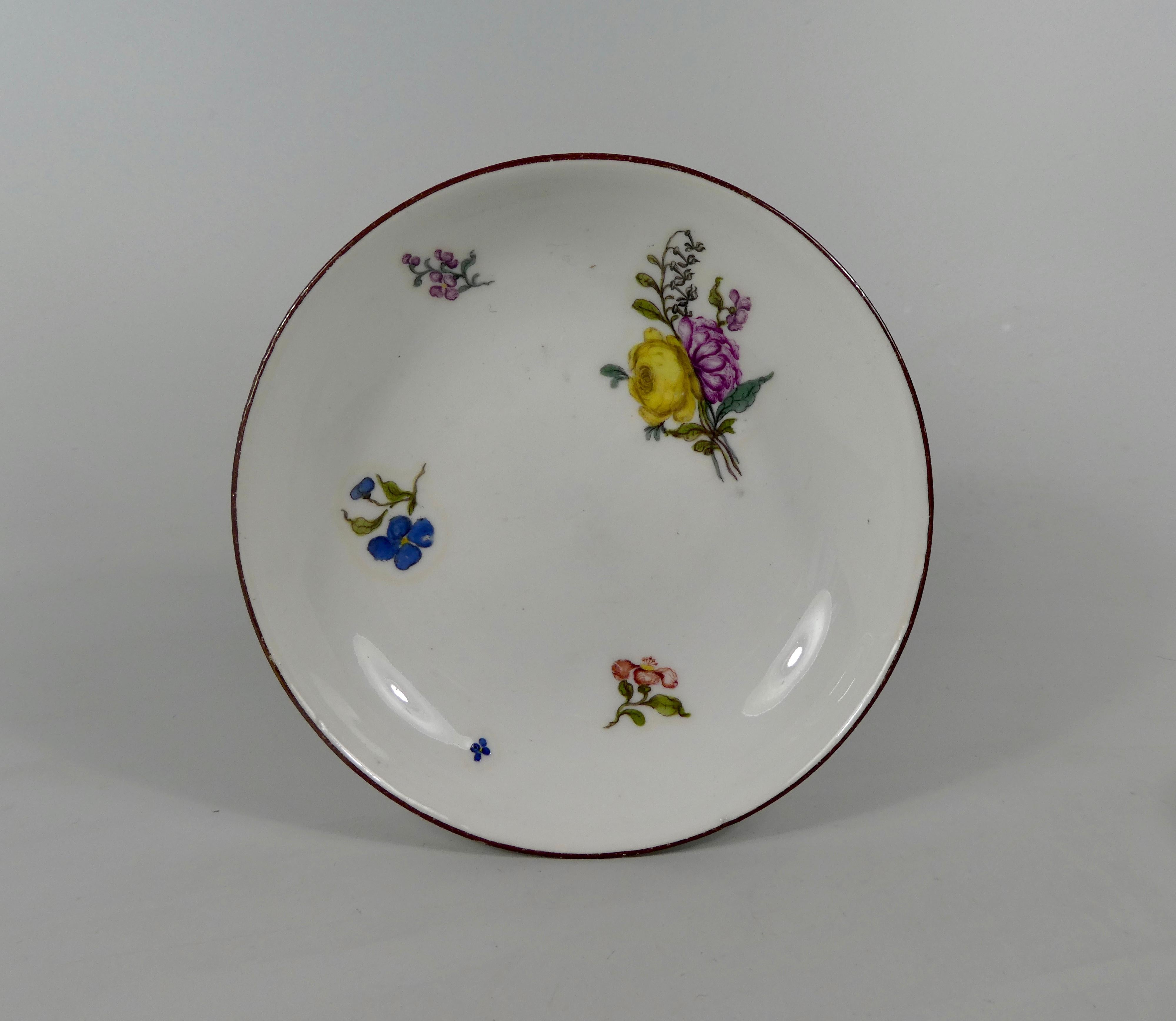Fine Meissen Porcelain cup and saucer, circa 1740. The cup having an elaborate scroll handle, and painted with a large spray of flowers, and further smaller sprays. The saucer similarly decorated.
Underglaze blue crossed swords mark to both