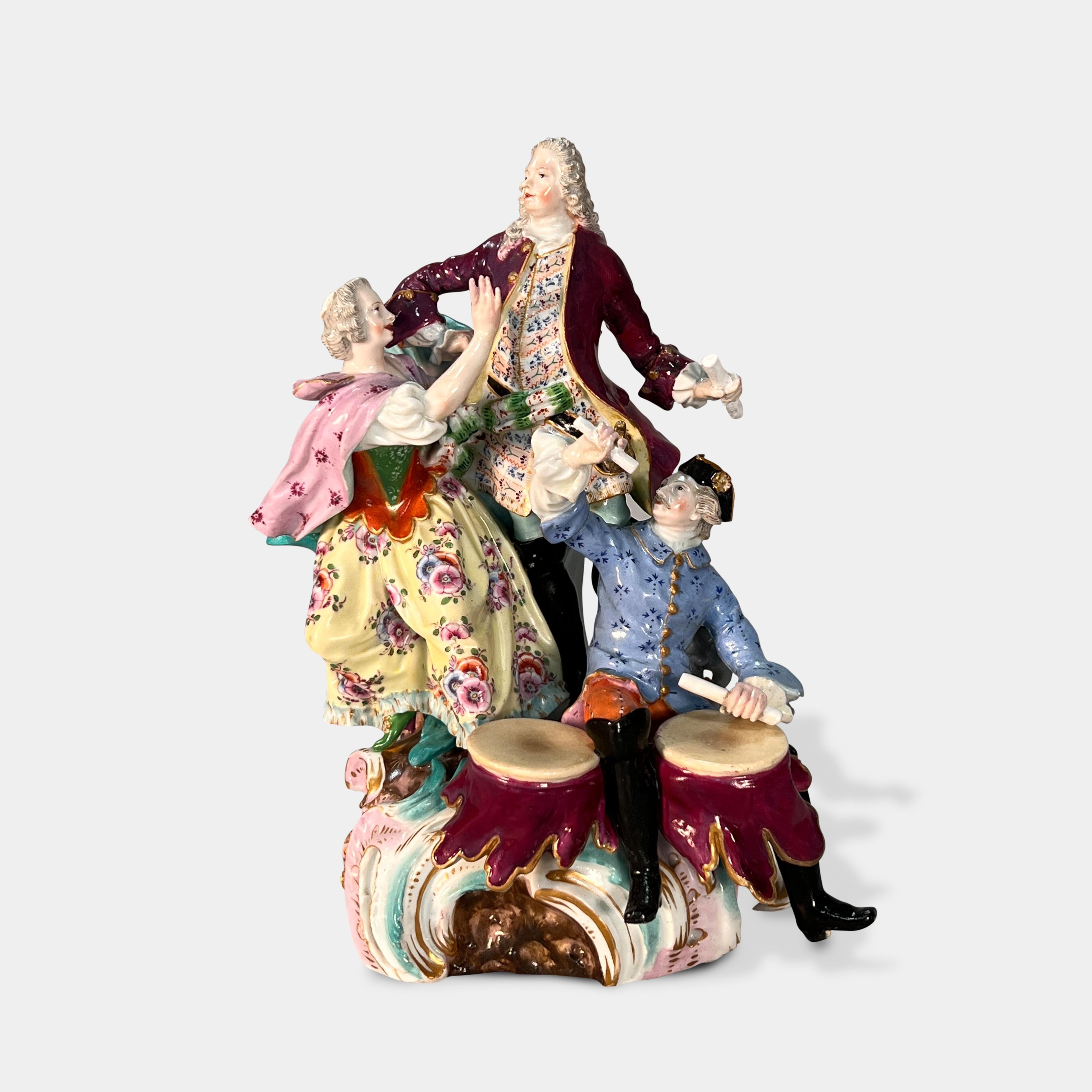 Eine schöne Figurengruppe aus deutschem Meissener Porzellan des 19. Jahrhunderts mit einer stehenden Dame, die einen stehenden Herrn anspricht, und einem Musiker, der zu ihren Füßen sitzt und trommelt.

Ende des 19. Jahrhunderts.

Blaue