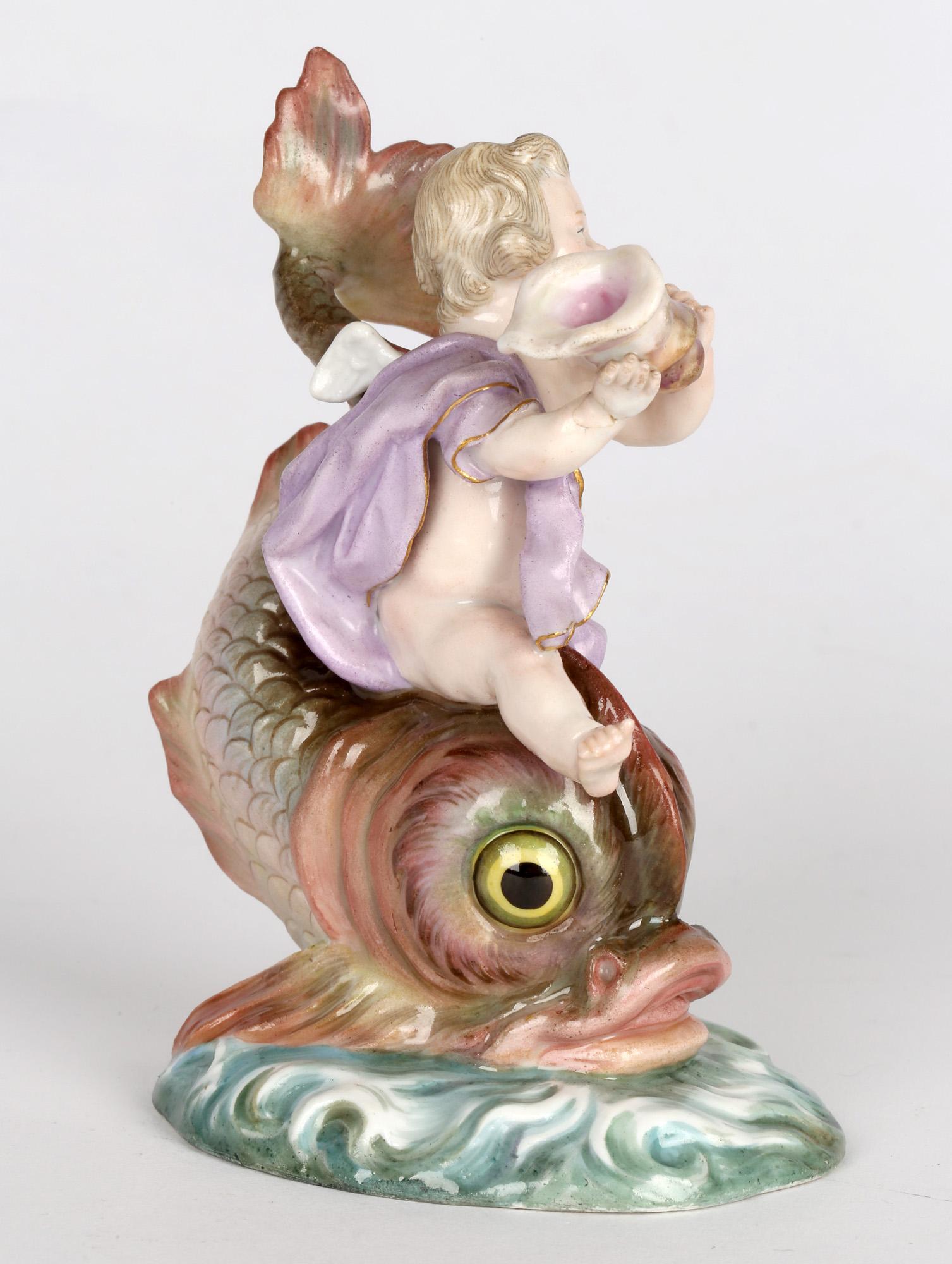 A rare and delightful German porcelain figure of a winged cherub playing a shell horn and riding on the back of a large fish dating we believe from the 19th century. This wonderful example is mounted on a large oval shaped base molded with waves and