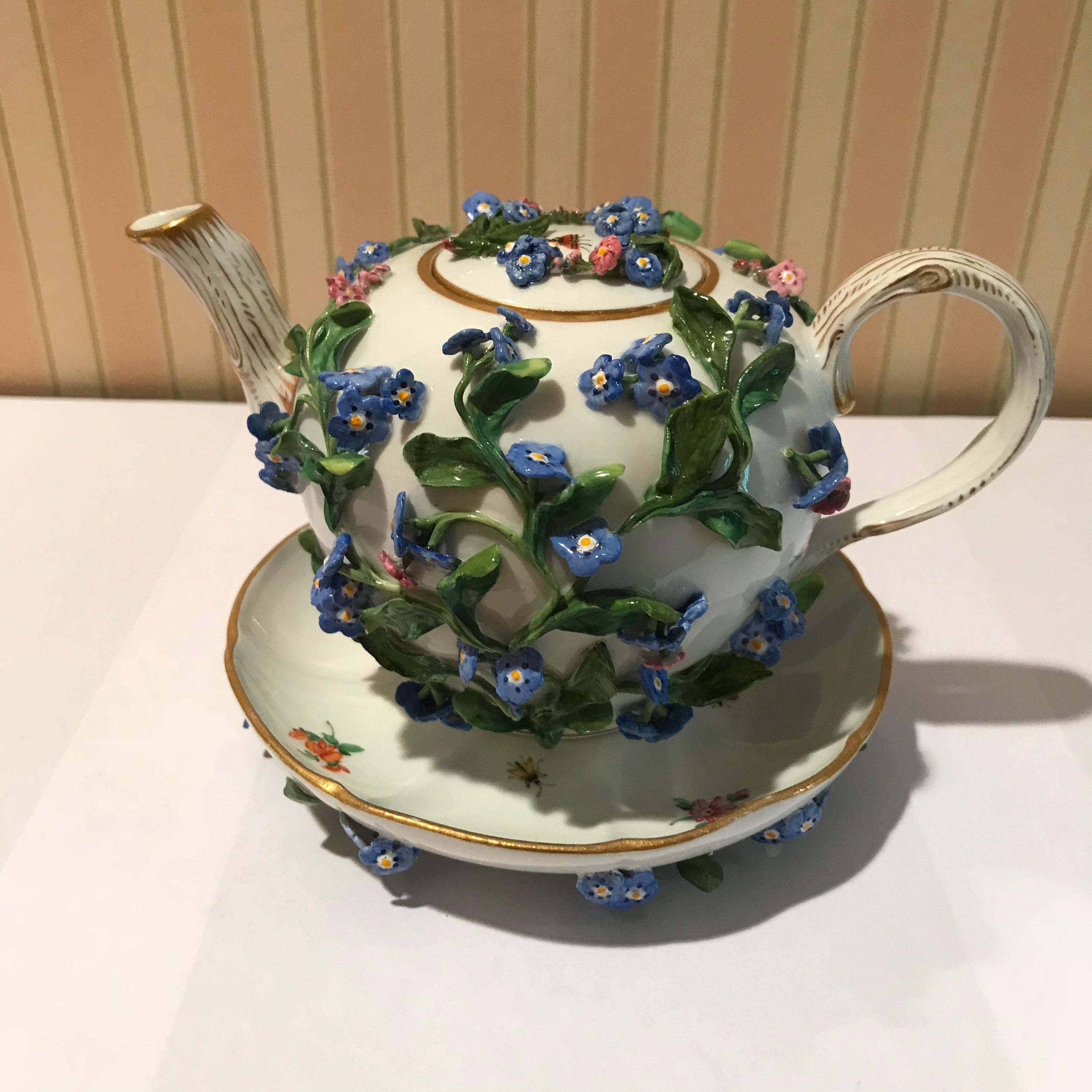 A lot of Meissen porcelain tea set encrusted with flowers. Lot comes with two ewers, miniature cup and saucer, lidded teapot, lidded cup, and cup and saucer.