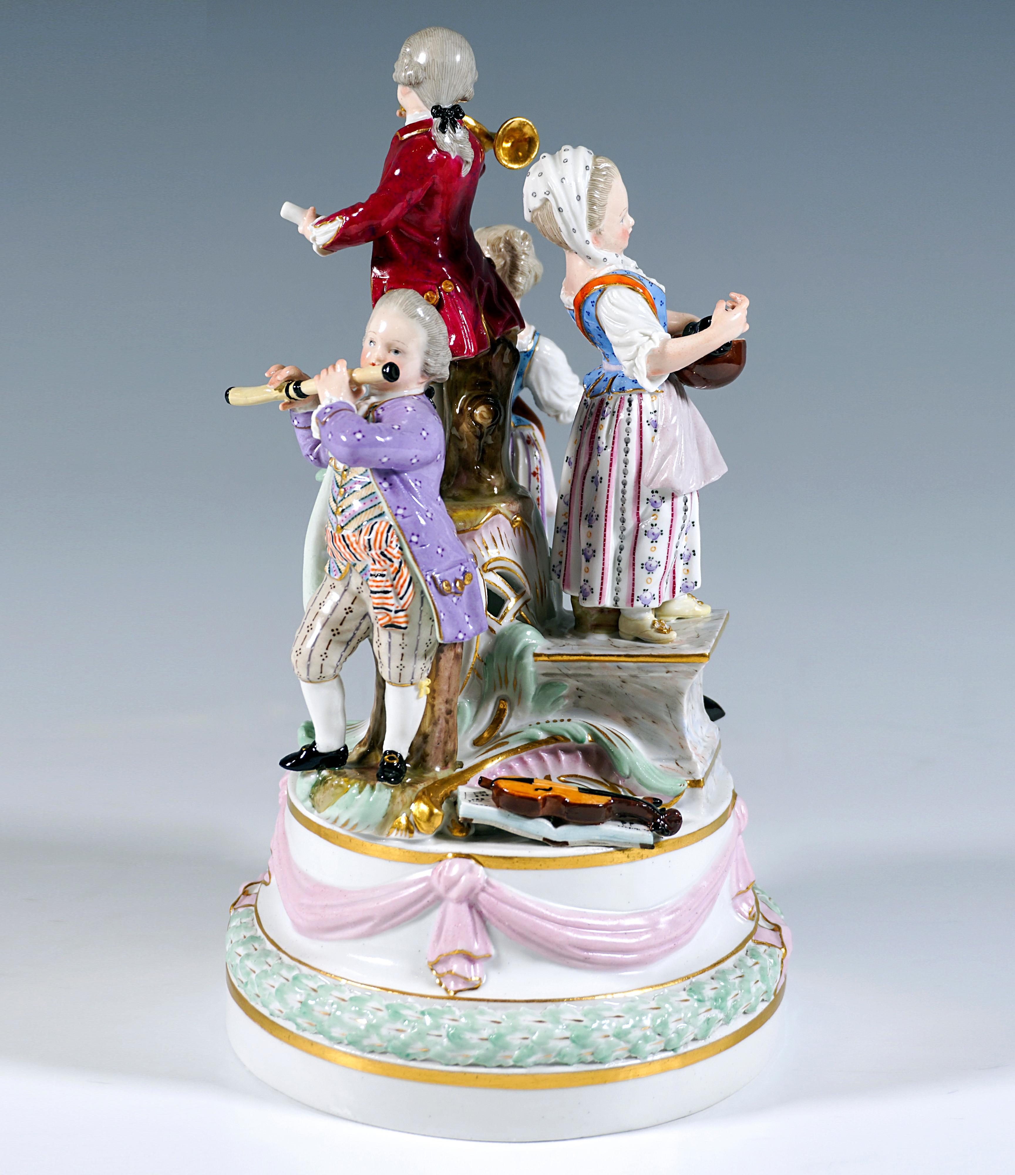 Excellent Meissen piece from the time the model was created:
Four children in festive rural rococo dress on a high, stepped round pedestal, decorated with a leaf wreath and bow festoon with gold ornamentation, on the pedestal further pedestals of