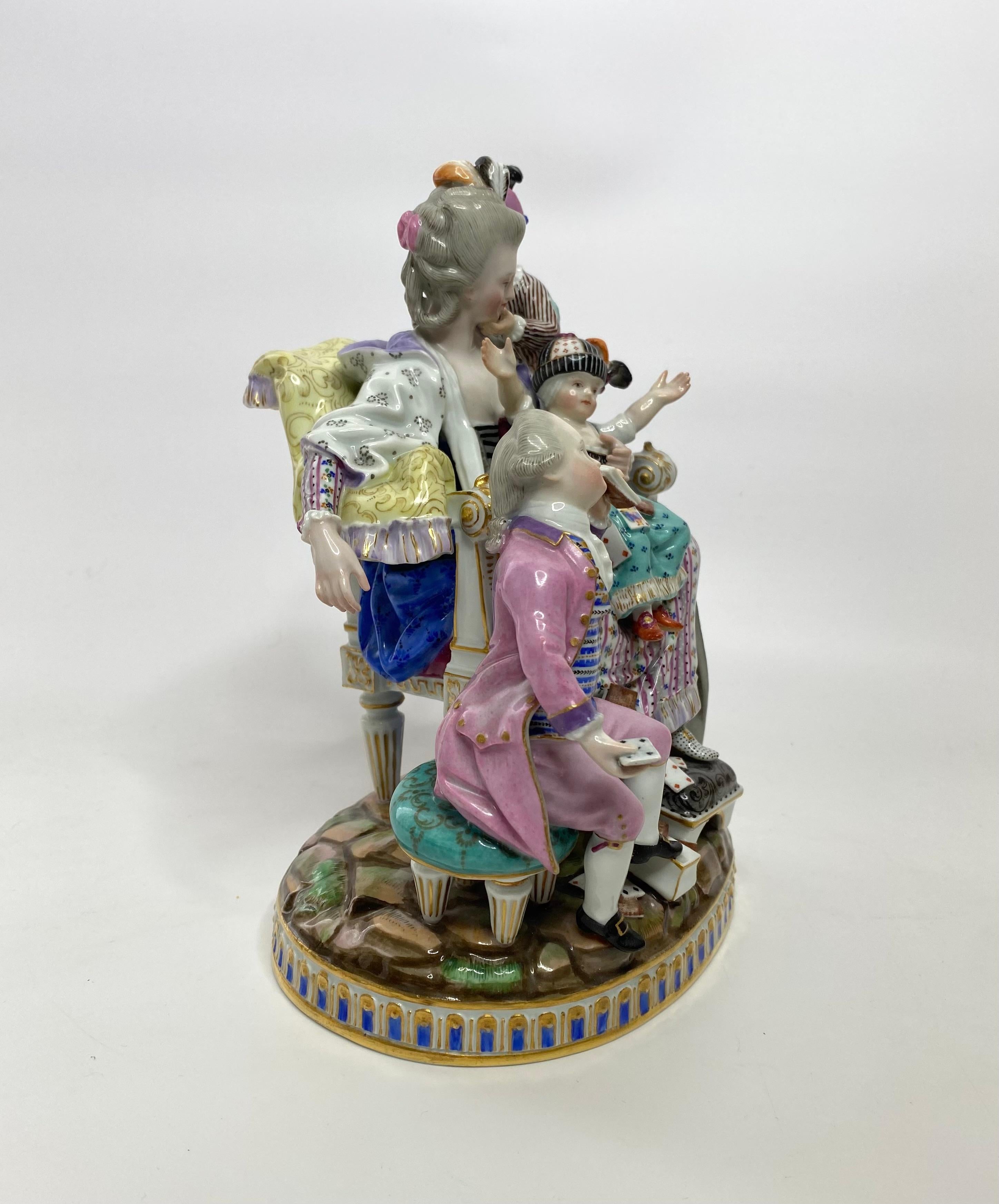 Meissen porcelain group, ‘The Good Mother’, c. 1870. Modelled after Michel Victor Acier, as a family group of a mother seated on a chair, playing cards with her children. She holds the toddler, seated upon her knee, whilst one of her sons, clambers