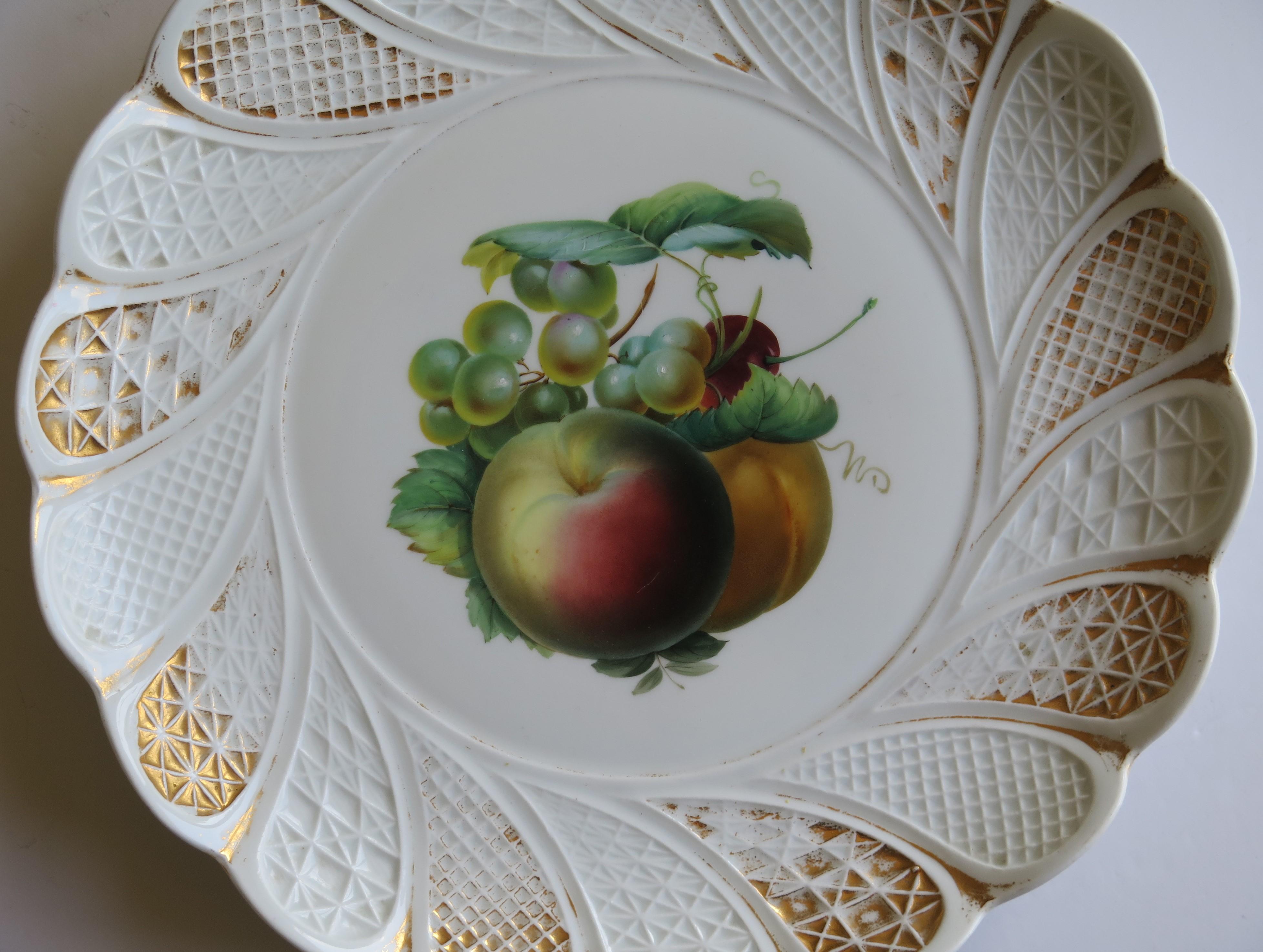 This is a beautiful large plate or charger with a finely hand painted pattern by the Meissen factory in fine white porcelain and dating to the 19th century, circa 1870.

The plate has a wavy rim with a moulded spiral lattice border and sits on a