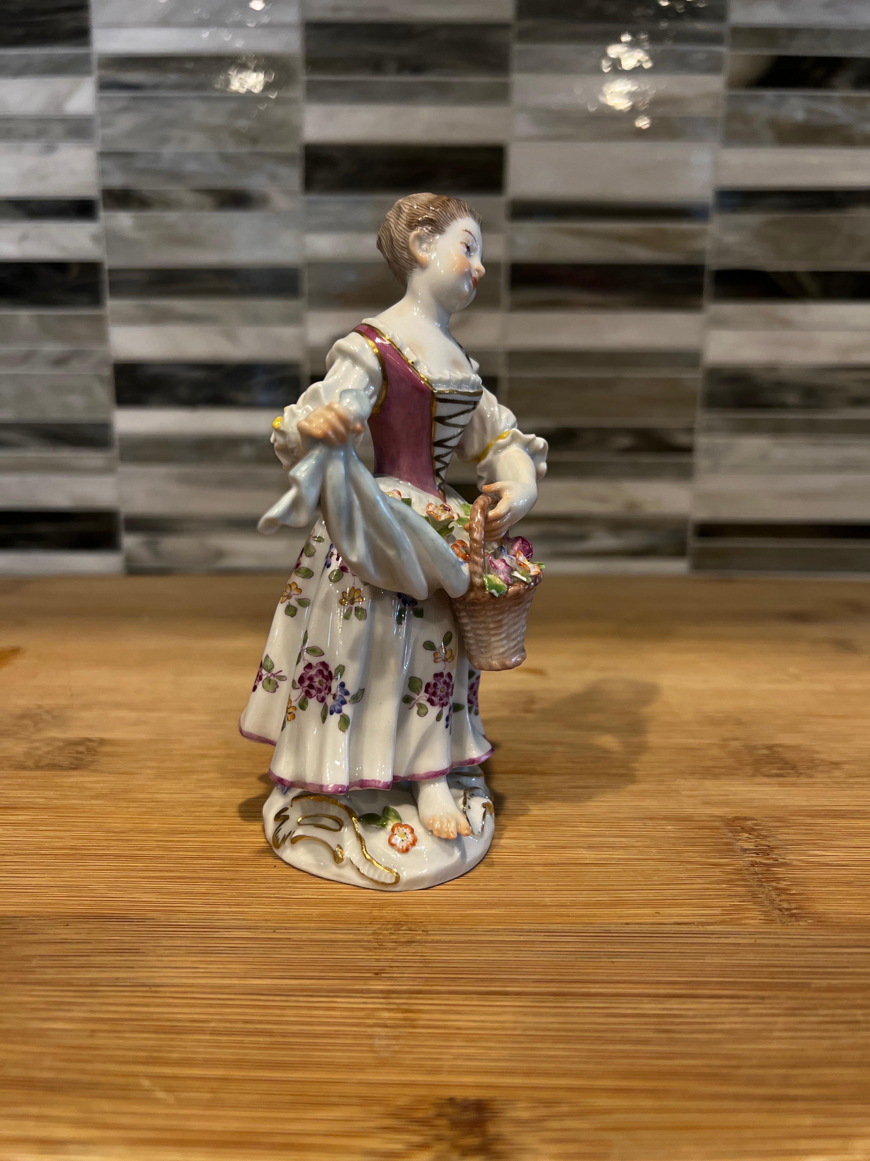 Nice small figurine of a little girl in dress and flowers, made by famous German manufactory Meissen.  The model was created in 1770s by Johann J. Kändler as a part of 