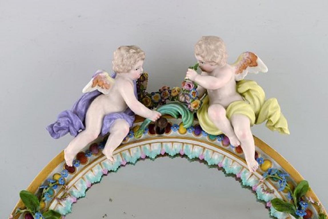 Meissen porcelain mirror. Decorated with angels and repousse flowers, circa 1900.
In very good condition. Minimal chips on repousse flowers.
Measures: 36 x 25 cm.
Stamped.









  