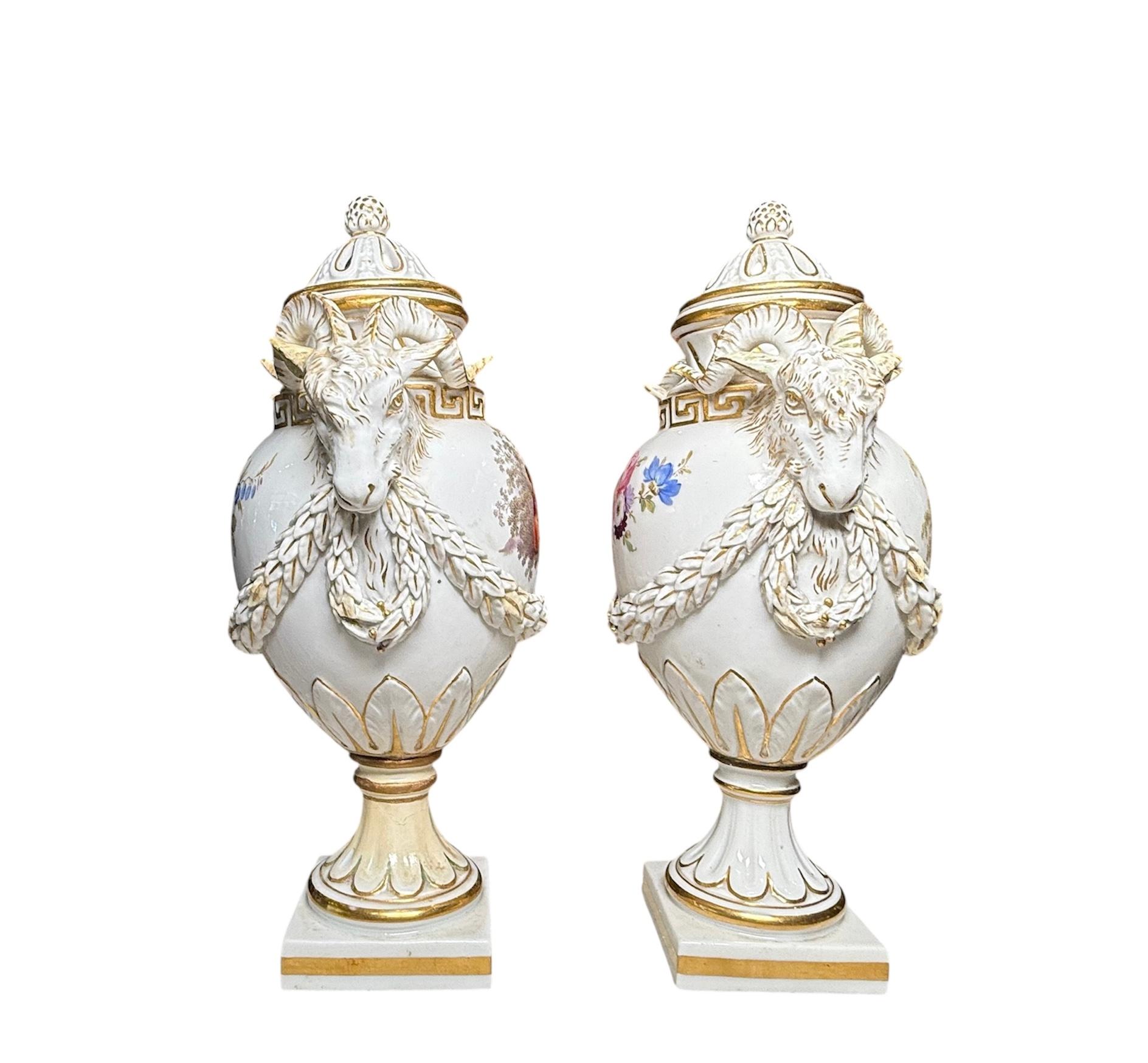 This Meissen Porcelain Pair of Potpourri’s Urn Vases were repaired. It depicts a pair of porcelain lidded urn vases hand painted  white color in the background with gilt details. The front center of the urns is hand painted with a romantic couple