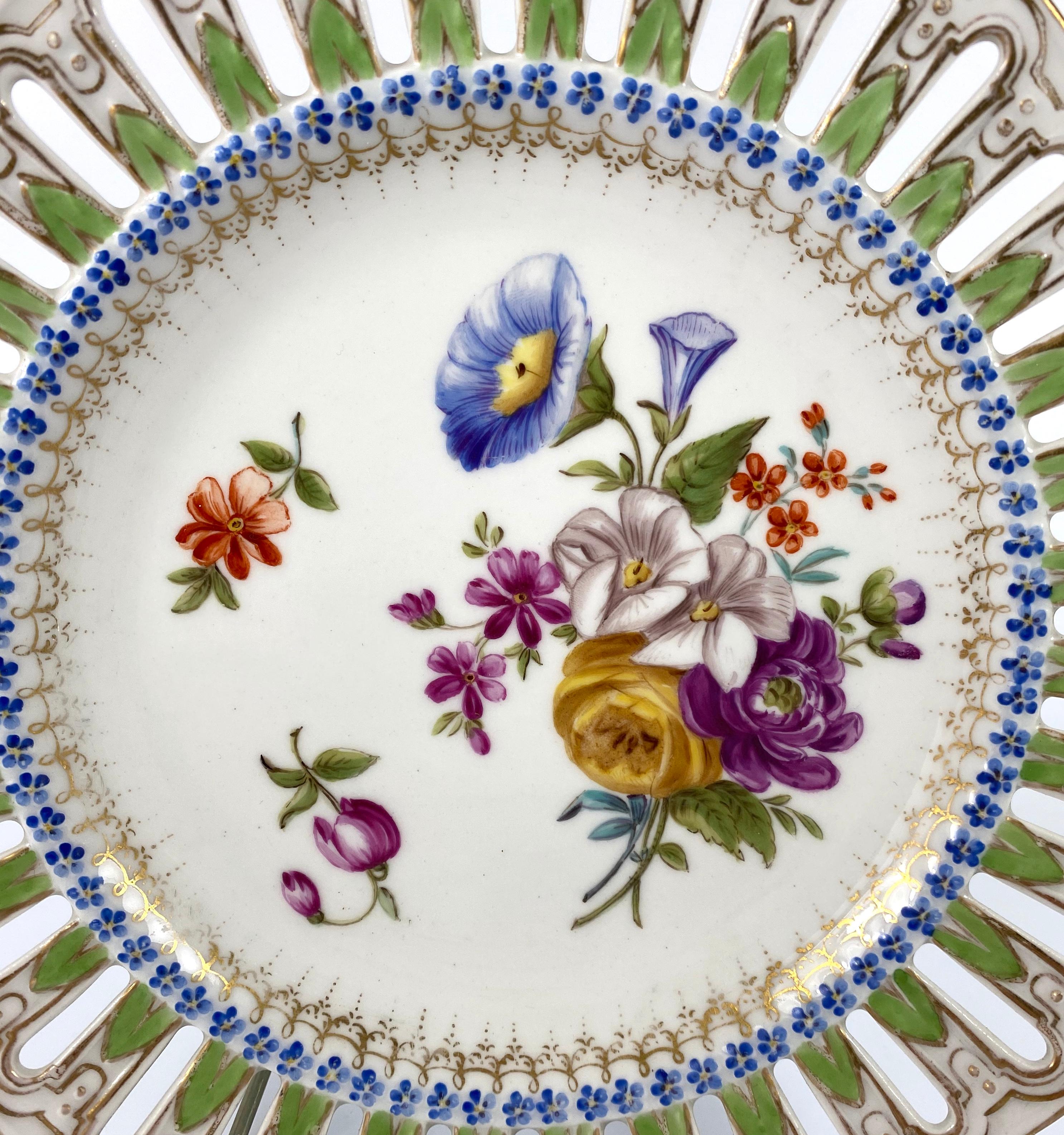 Meissen Porcelain reticulated plate, circa 1860. Beautifully hand painted to the centre, with a spray of spring flowers, and further sprigs, within a moulded flowerhead border. The outer rim, pierced, and gilded, around a continuous green acanthus