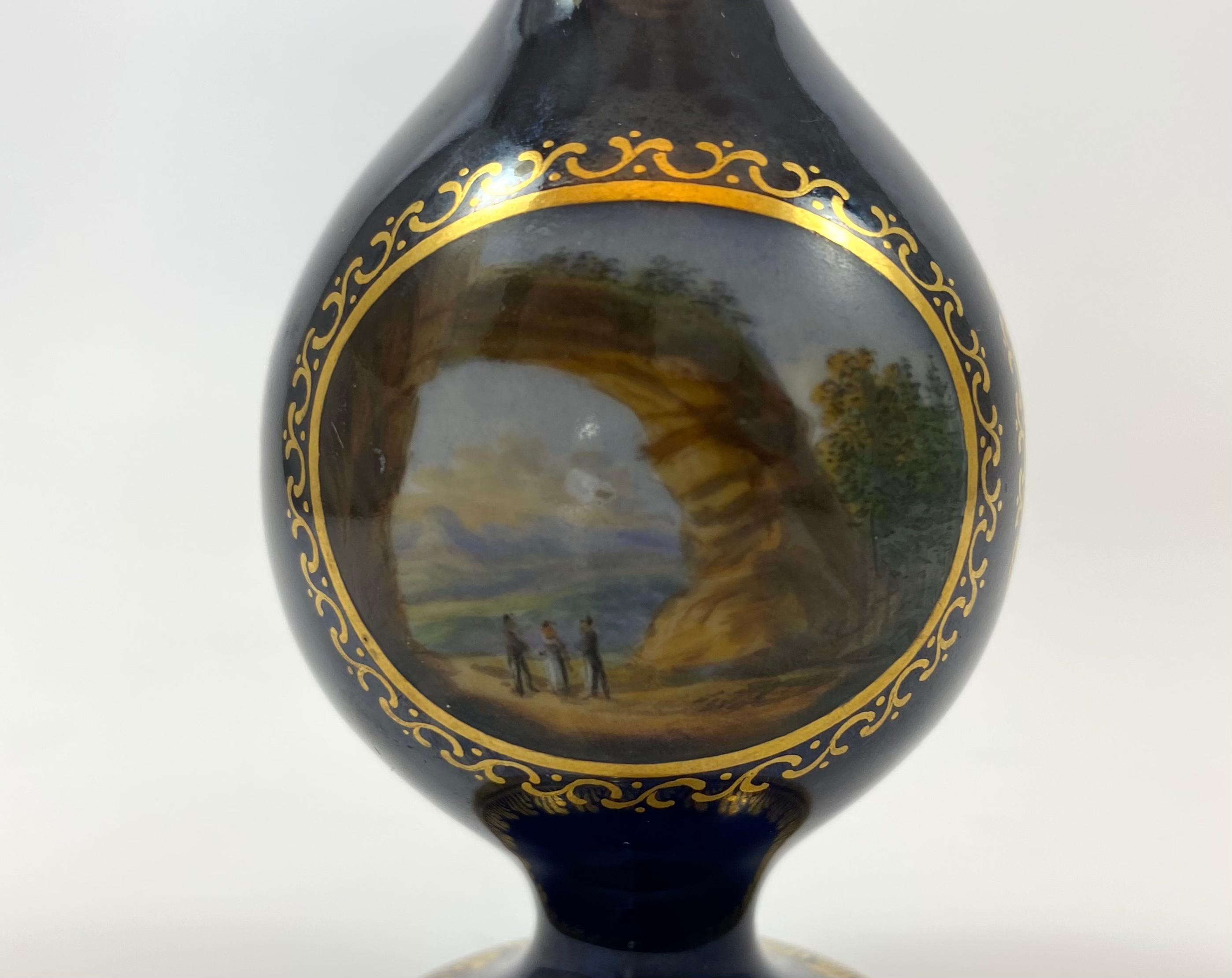 Meissen porcelain scent bottle, c. 1790, Marcolini Period. The scent bottle modelled after an Islamic rose water dropper, and hand painted with three gilt scroll panels, containing views in Germany. All on a cobalt blue ground.
Having the original