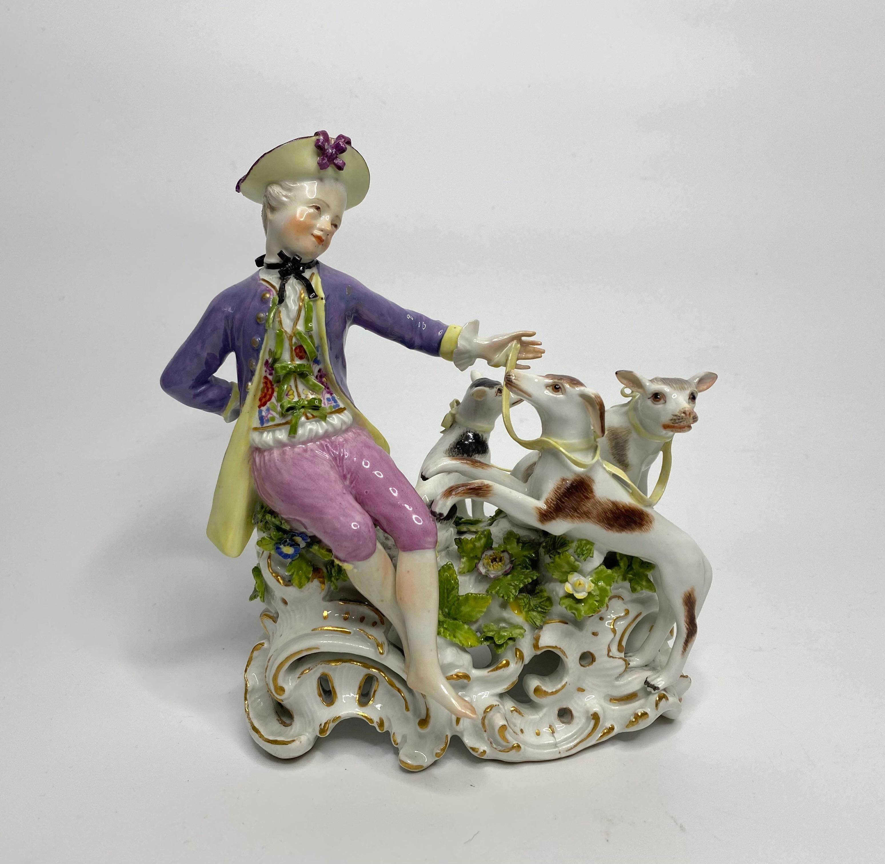 A fine pair of Meissen porcelain figure groups, c.1765 -1775. Elaborately modelled by Carl Christoph Punct, as a shepherd and shepherdess, in 18th Century dress, and set upon open rocaille bases.
The bare footed shepherd with three hounds, above a