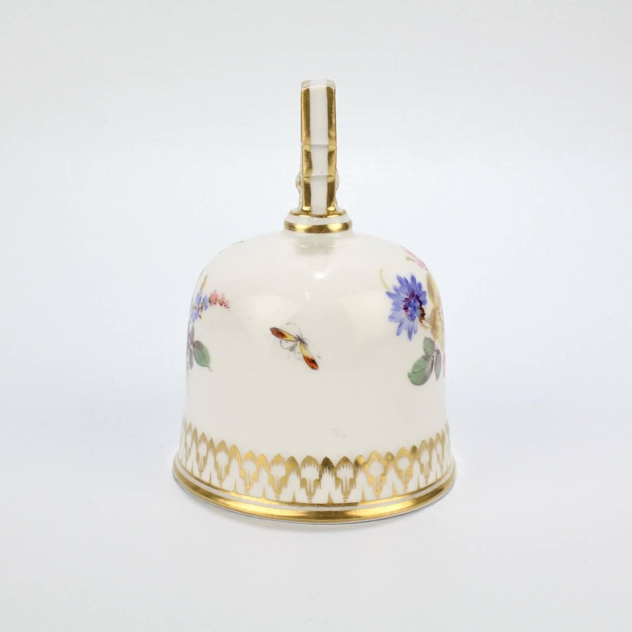 A fine antique Meissen porcelain table bell with Dresden flowers (or Deutsche Blumen) decoration.

Each side bears a different floral bouquet.

The interior has a factory original small wooden clapper and bears a blue underglaze crossed swords